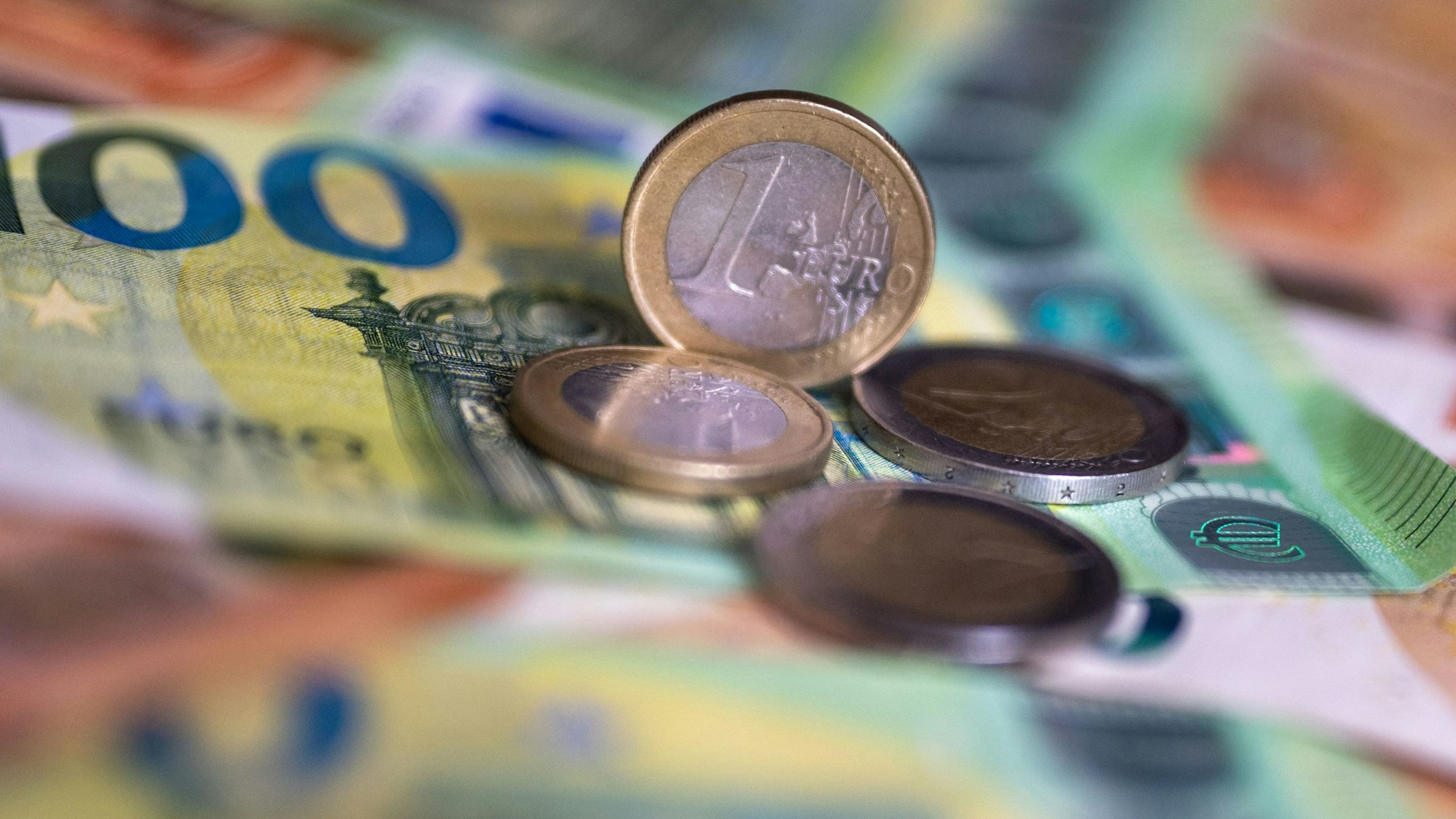 Geldscheine mit dem Wert von 100 und 50 Euro und Münzen liegen auf einem Tisch.
