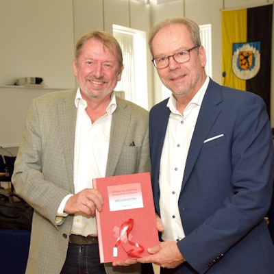 Das Foto zeigt zwei Männer bei einer Übergabe einer Petition.