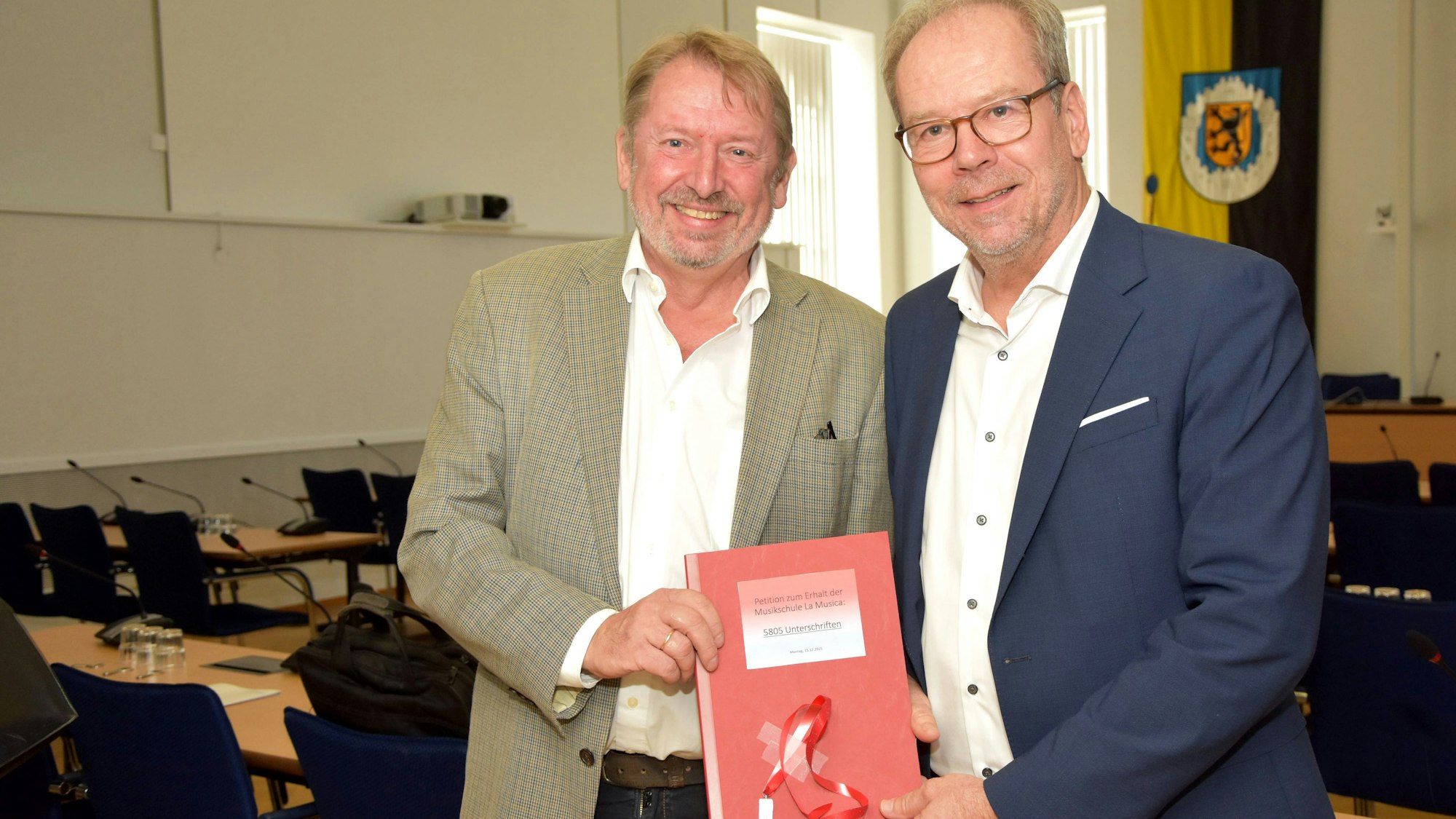 Das Foto zeigt zwei Männer bei einer Übergabe einer Petition.