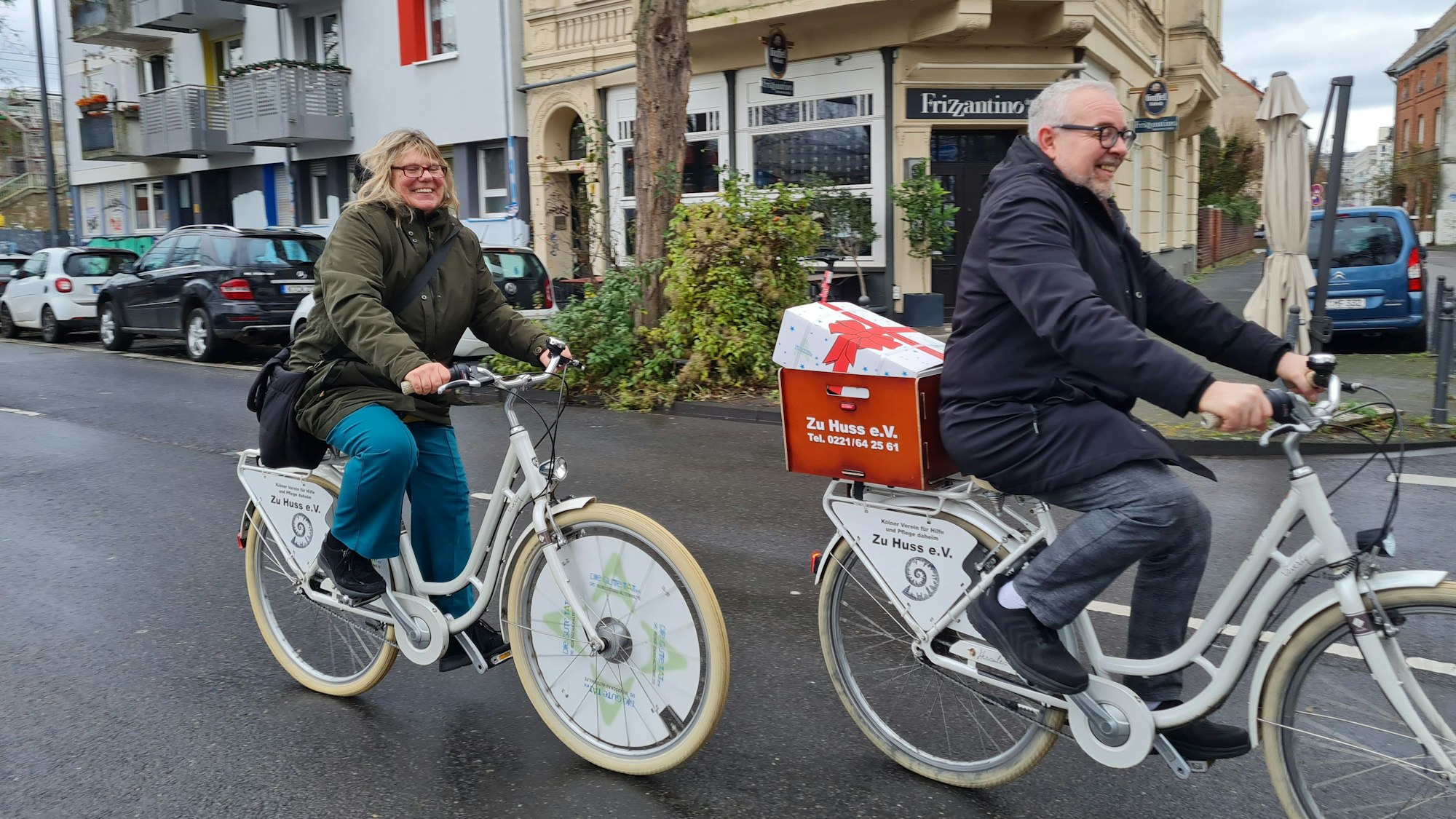 Dietmar Saxler und Erika Fehring von „Zu Huss e.V.“ überbringen mit Fahrrädern der Rundschau-Altenhilfe ein Altenhilfe-Paket.