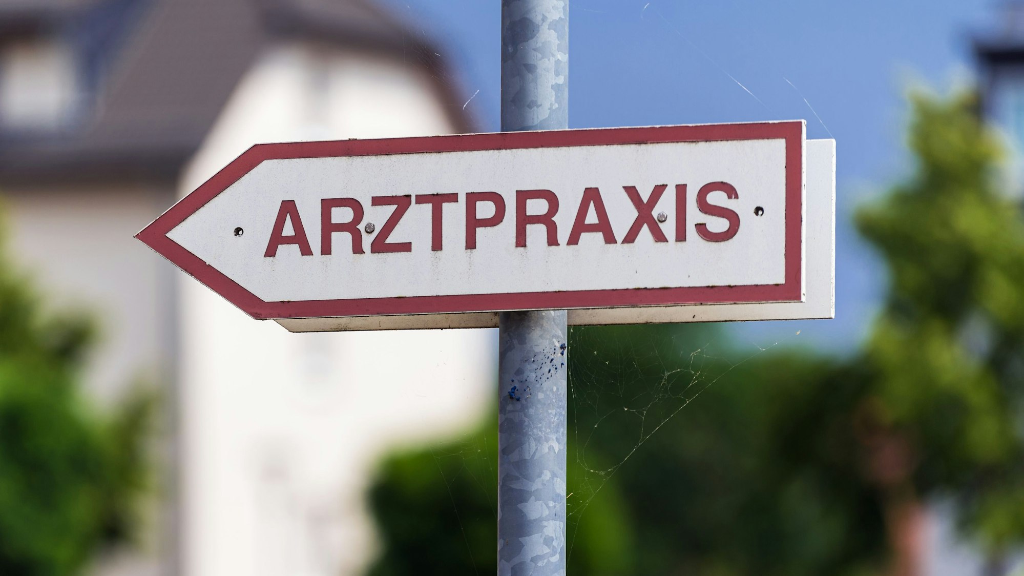 Ein Schild «Arztpraxis» steht an der Straße.