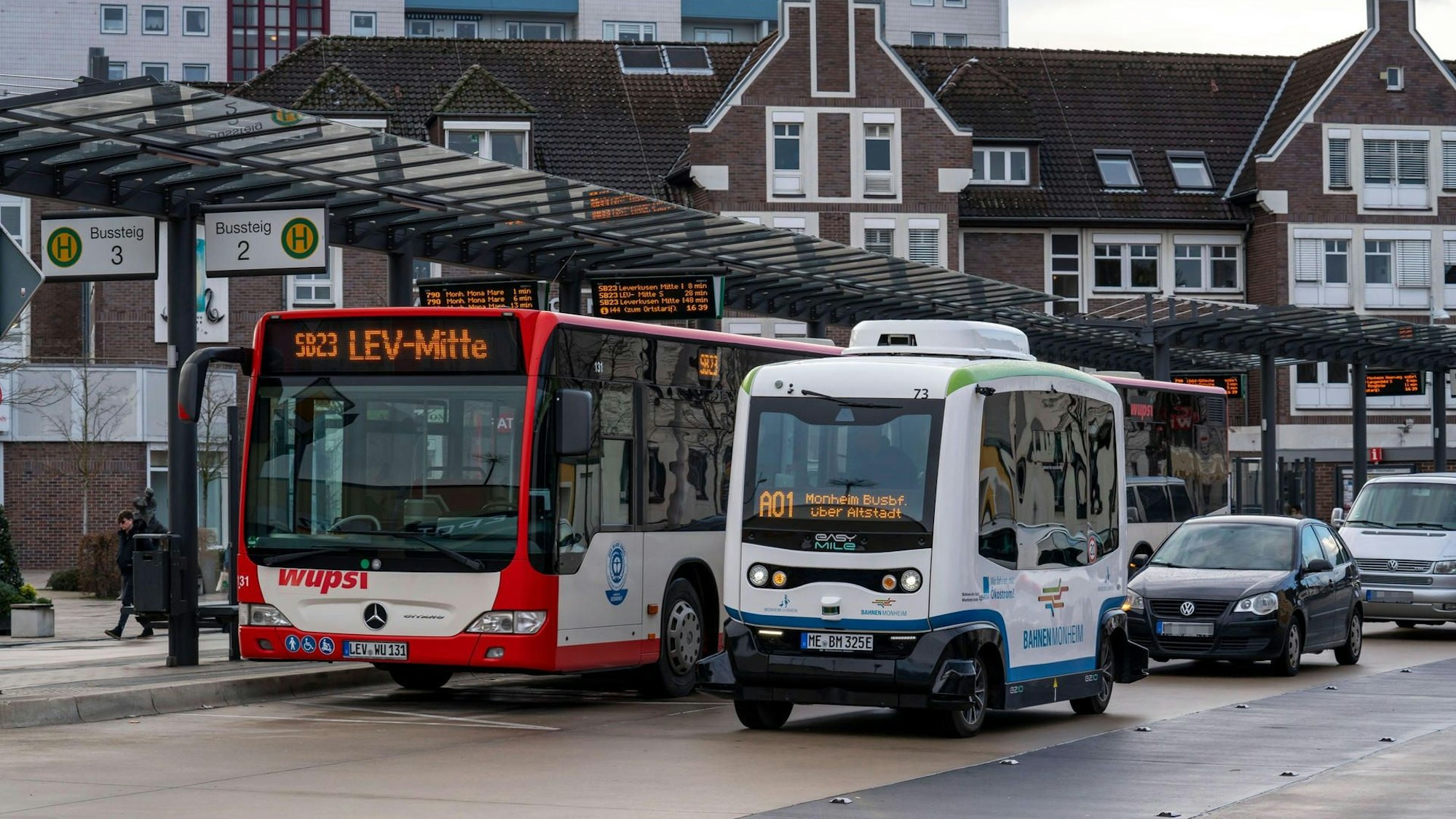 Zu sehen ist ein autonom fahrenden Linienbus in Monheim neben einem regulären Linienbus.