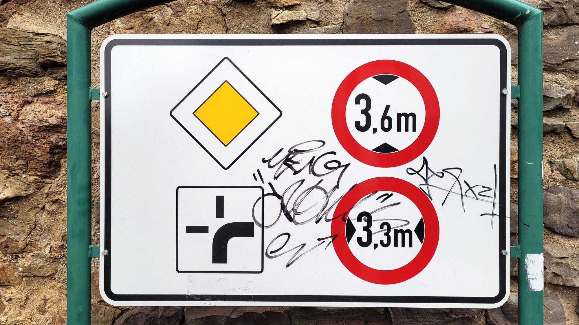 Auf einem Verkehrsschild sind Filzstift-Kritzeleien zu erkennen.