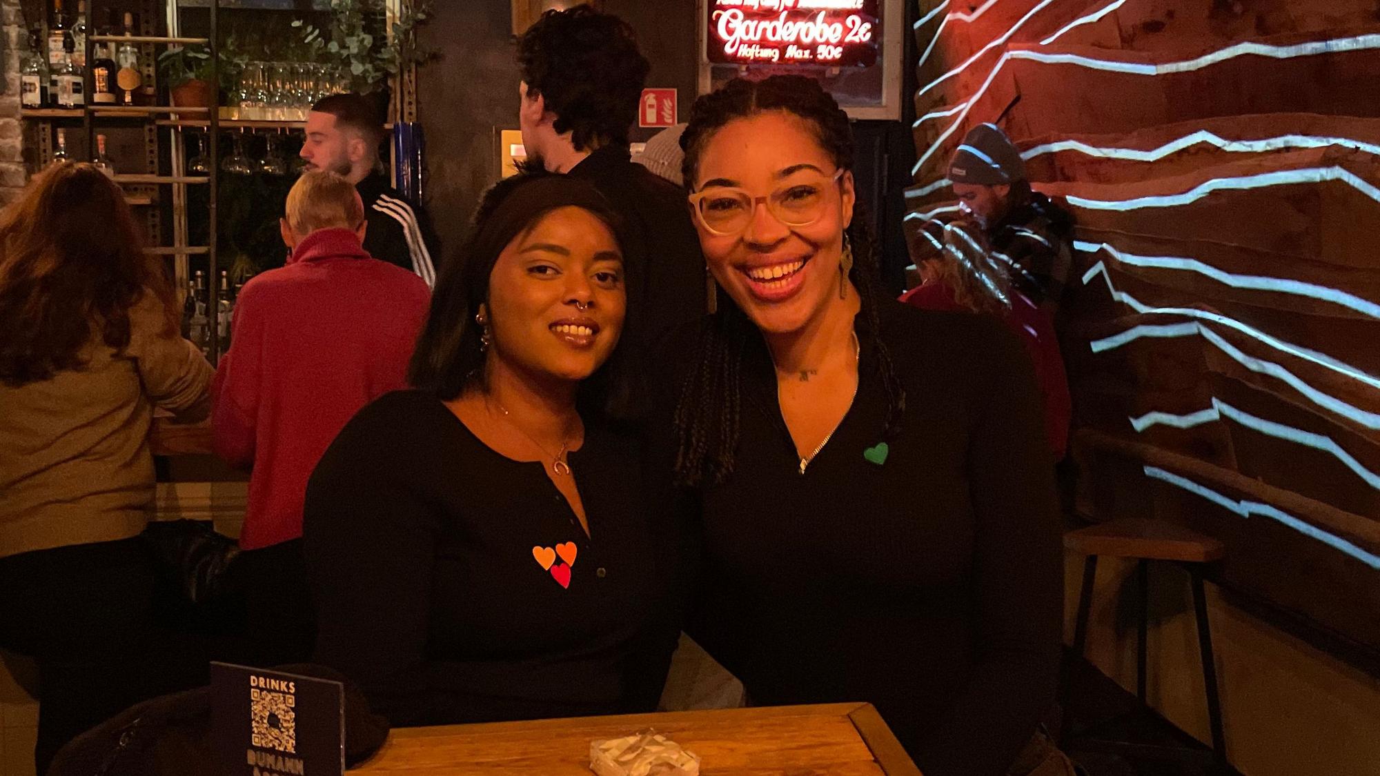 Finden Online-Dating anstrengend: Die Freundinnen Dora (l.) und Naemi sind zu Gast bei der Veranstaltung „Love At First Slide“ im Bumann & Sohn in Ehrenfeld. Die Herz-Sticker signalisieren den eigenen Status und Typ.