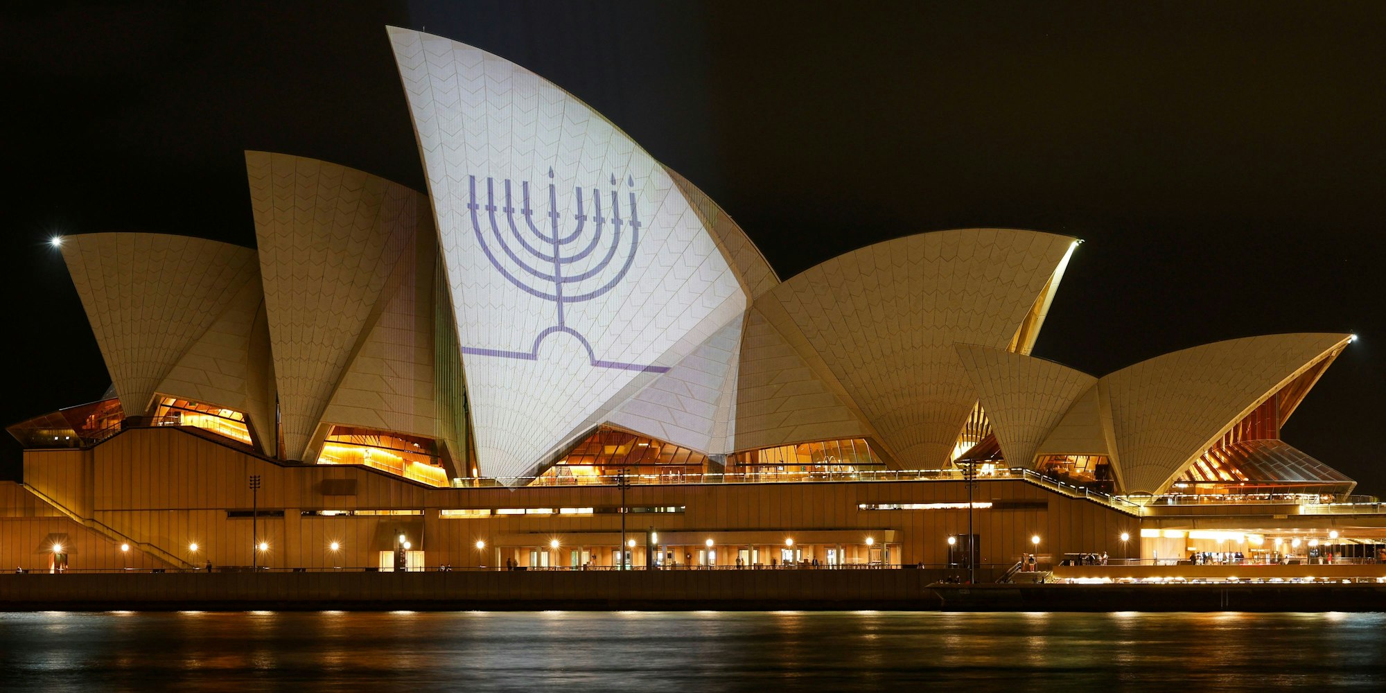 Die Segel des Opernhauses von Sydney sind in Gedenken an die Getöteten am Bondi Beach mit Kerzen auf einer Menora beleuchtet.