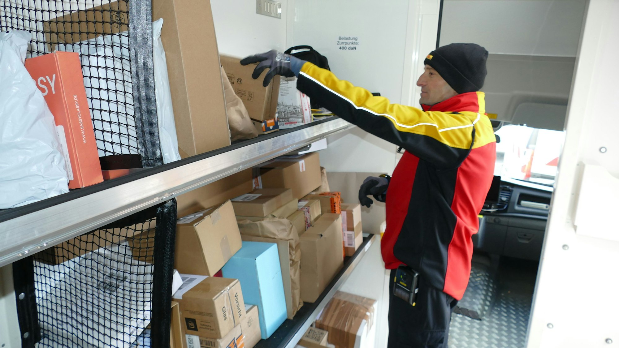 Naser Shkelzeni in seinem elektrisch betriebenen Zustellerfahrzeug: Bis zu 270 Pakete am Tag muss er vor Weihnachten ausliefern.