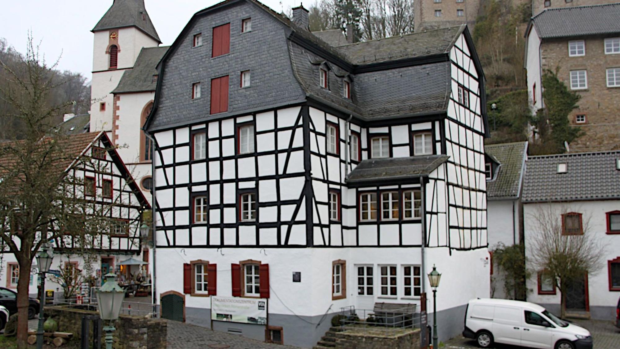 Beim Gildehaus handelt es sich um ein mehrstöckiges Fachwerkgebäude im Ortszentrum von Blankenheim. Im Hintergrund ist die Kirche zu sehen.