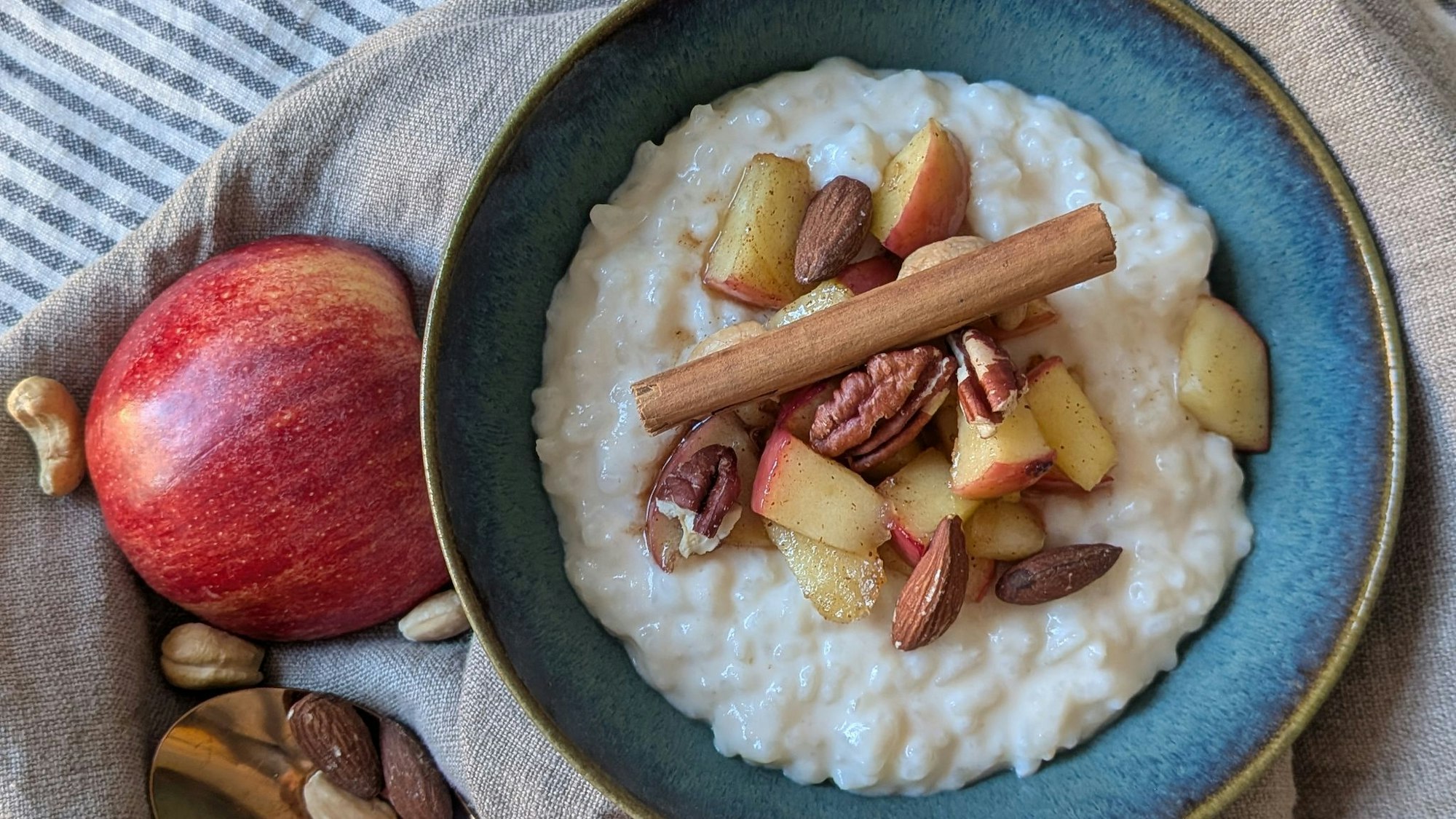 Der Milchreis ist mit Apfel, Zimt und Nüssen getoppt und eignet sich sowohl als Hauptspeise als auch als Dessert.
