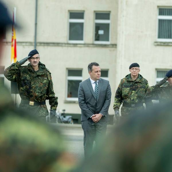 Drei Bundeswehrsoldaten und ein Zivilist stehen in einer Reihe auf dem Hof der Kaserne in Euskirchen.