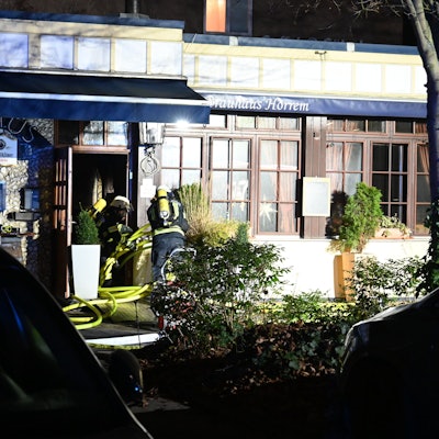 Das Bild zeigt Feuerwehrleute vor der Gaststätte.