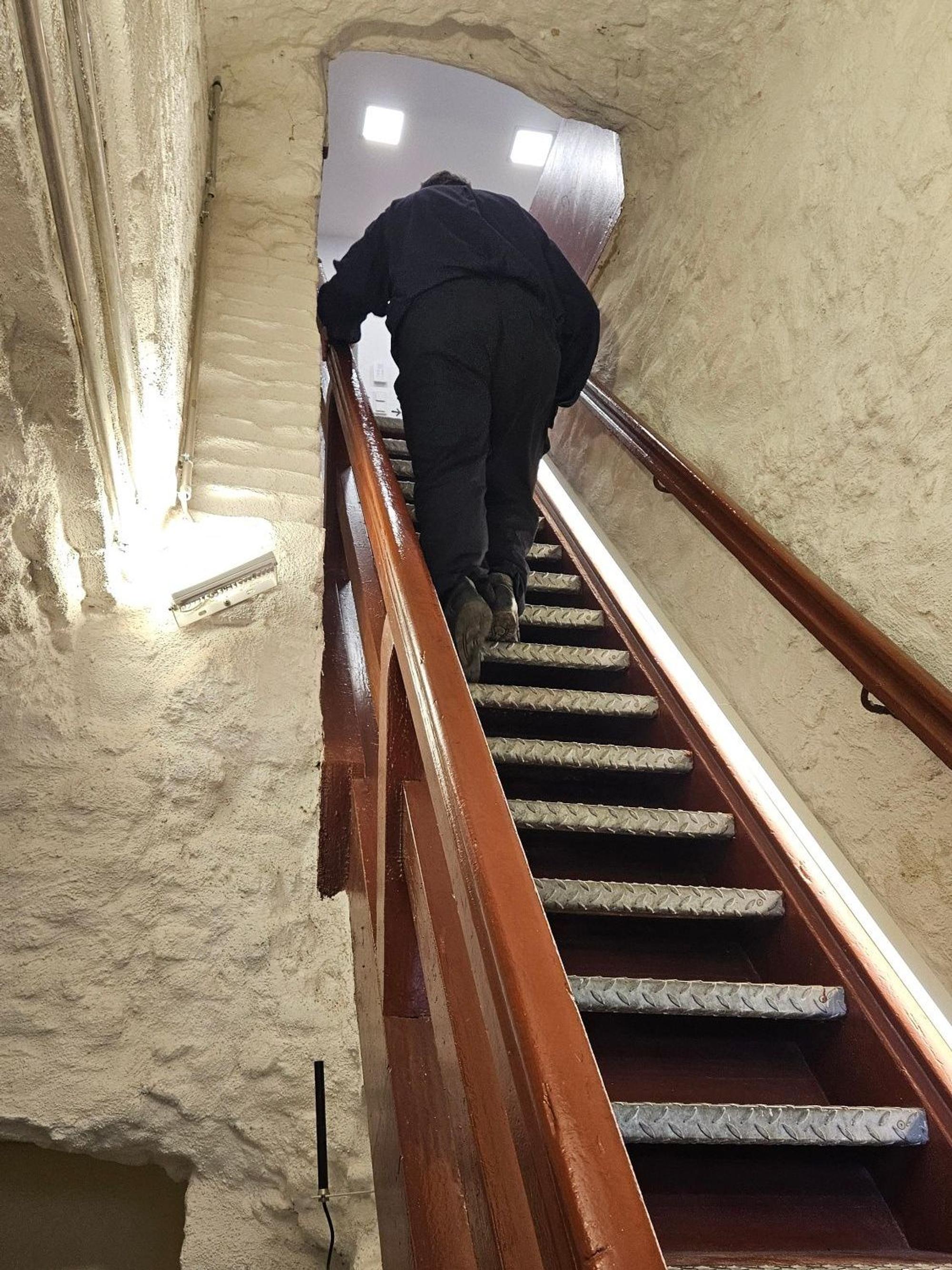 Zu sehen ist ein Mann auf einer steilen Treppe.