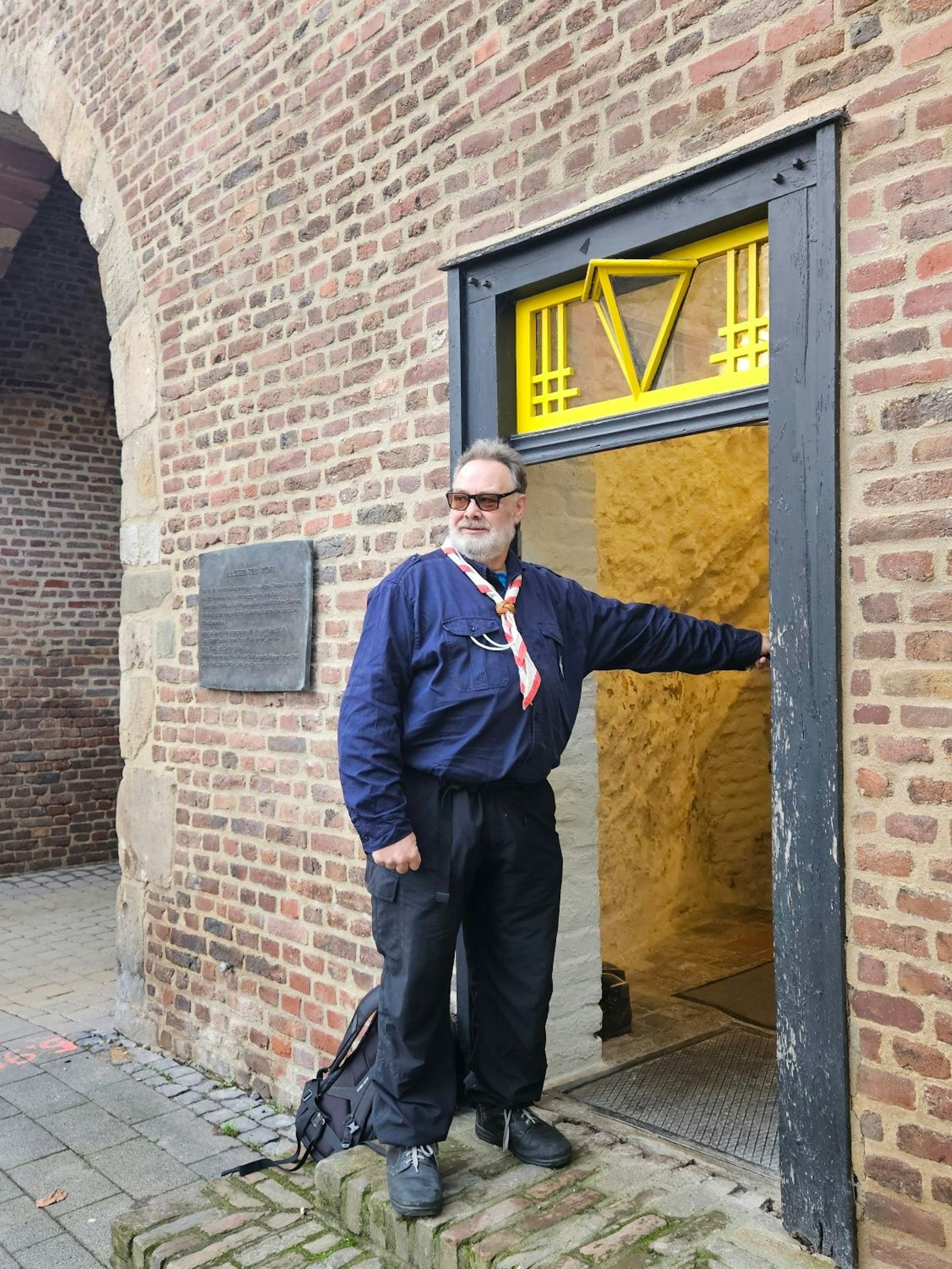 Zu sehen ist ein Mann vor einer Pforte ins Aachener Tor.