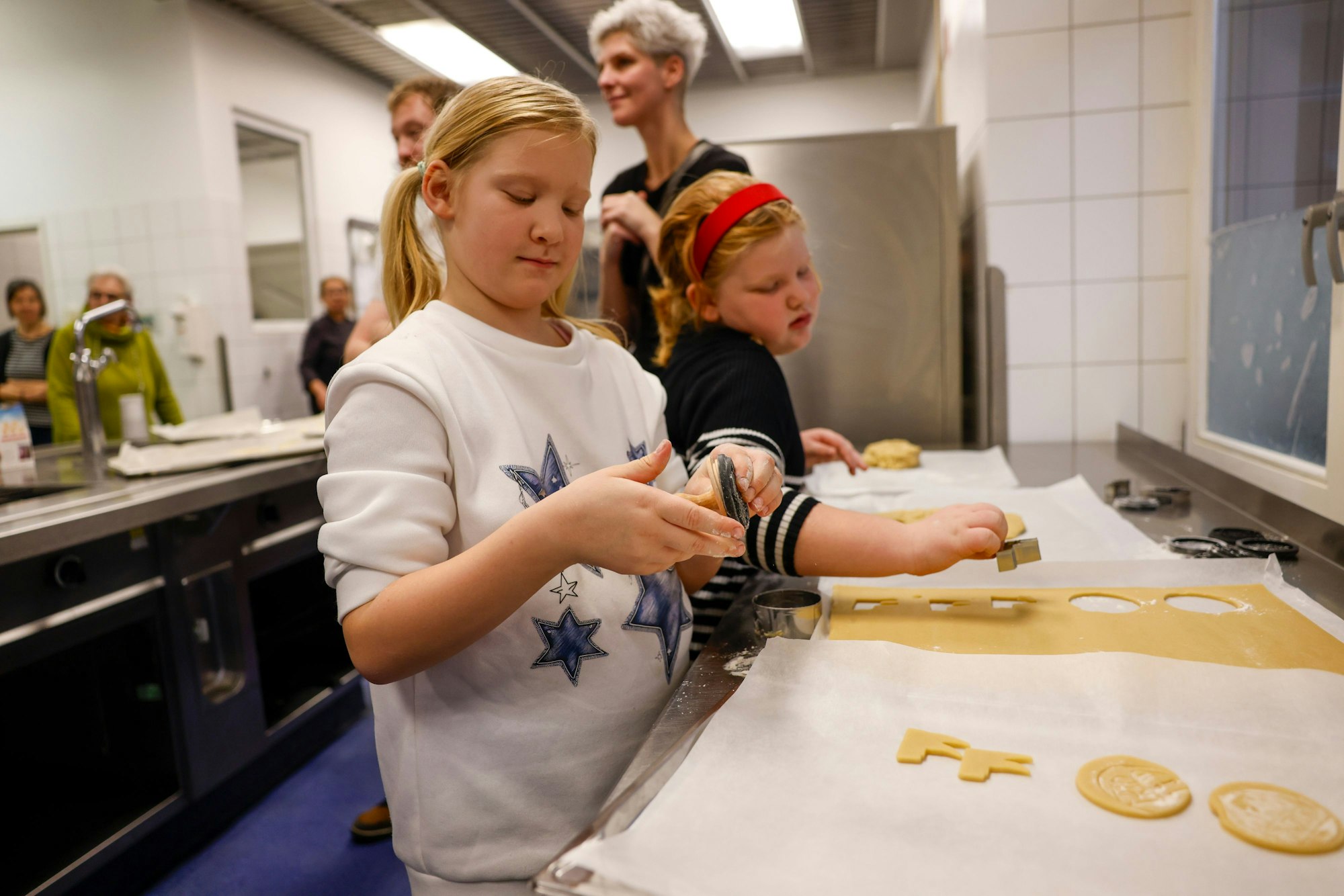 Lisa-Marie und Isabell stempeln Keks-Motive.