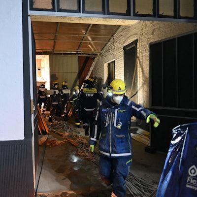 Zu sehen sind Helfer des Technischen Hilfswerks in einem Haus. Sie tragen Atemschutzmasken.