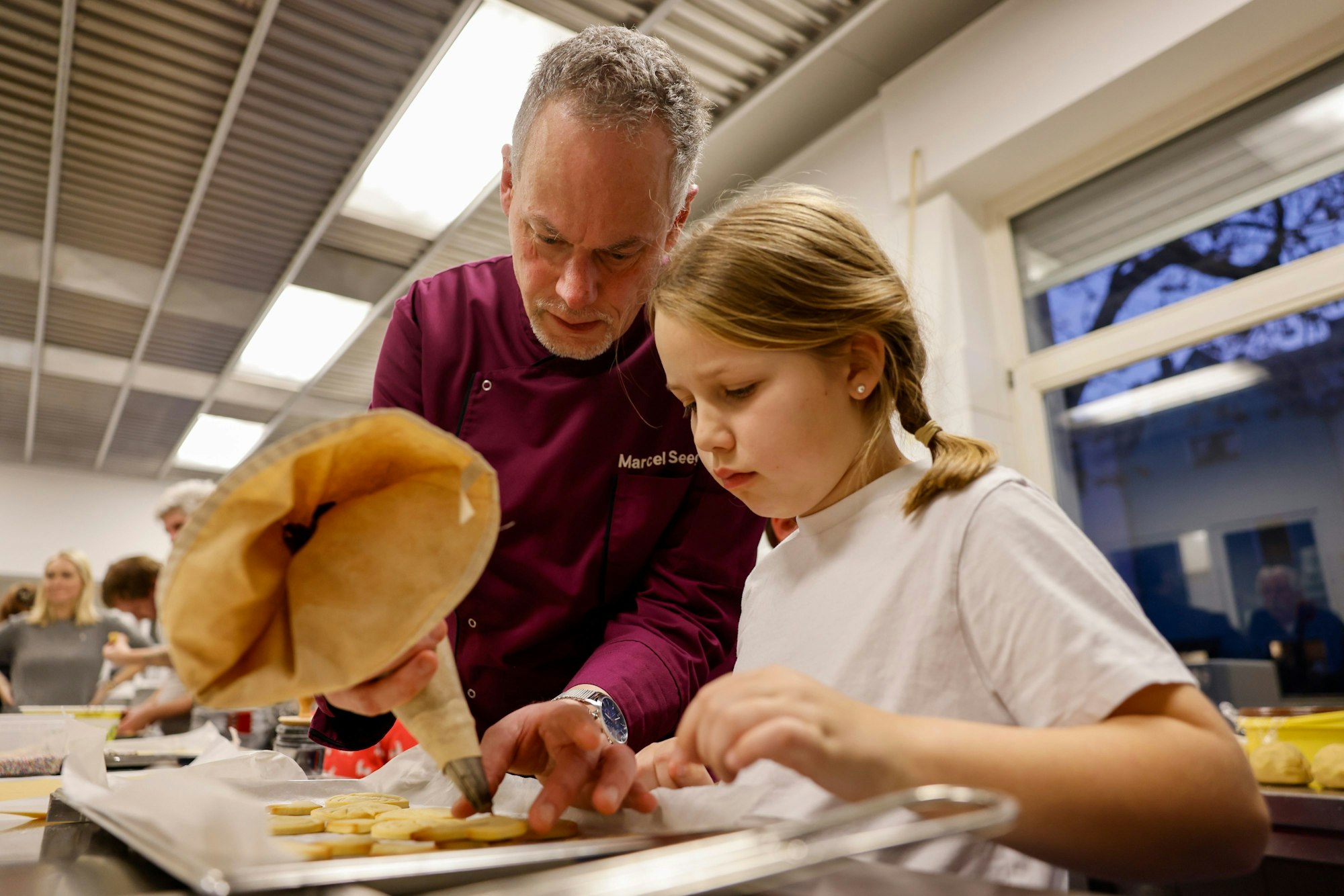 Marcel Seeger und Paula setzen mit Nougatmasse einen 3D-Dom zusammen.