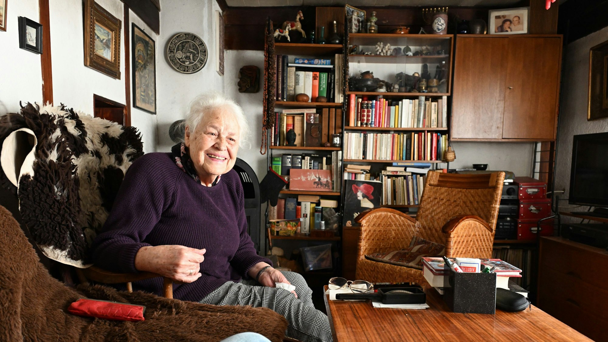 Frau Fuchs sitzt im Wohnzimmer auf ihrem Sessel.