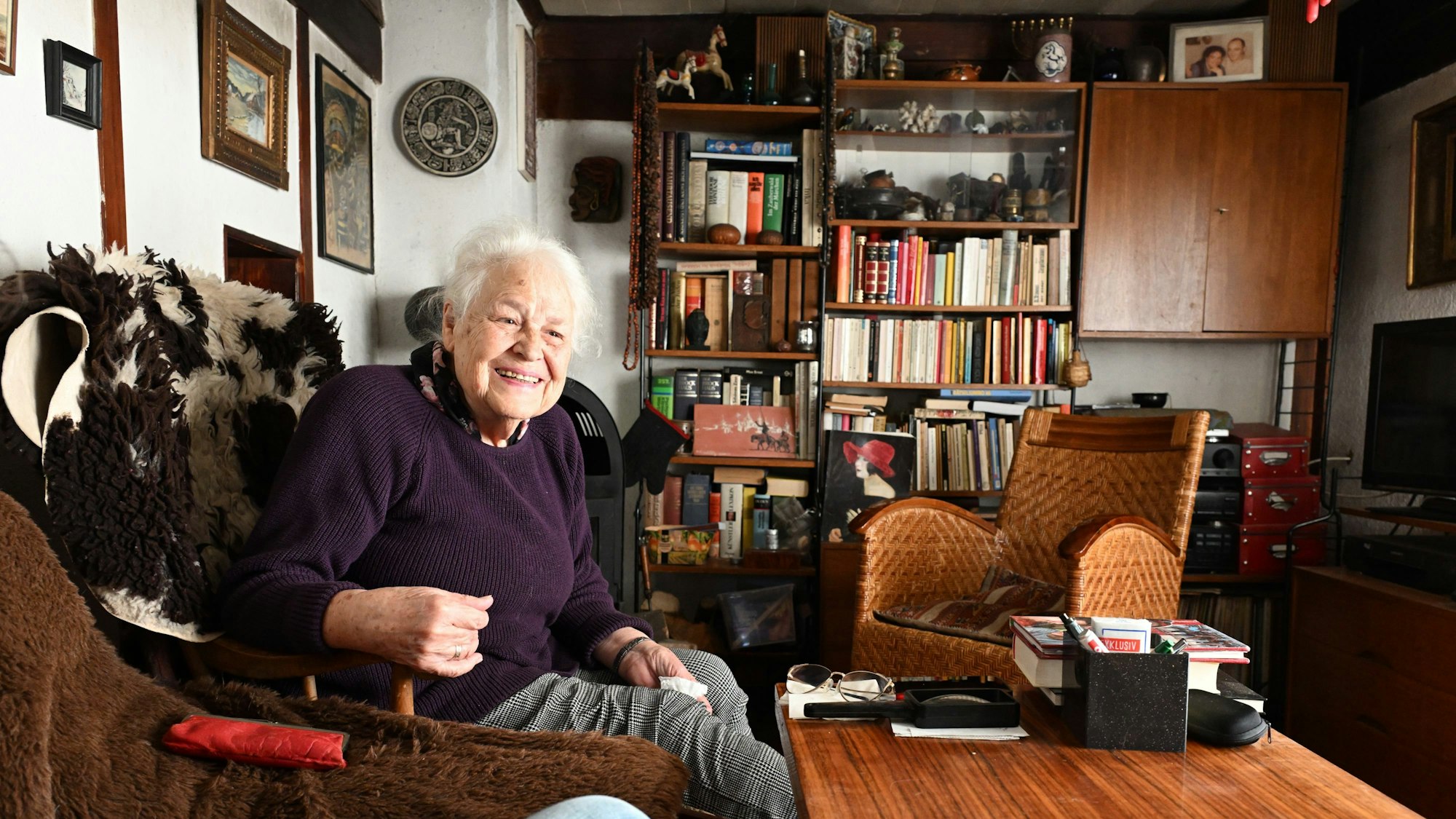 Frau Fuchs sitzt im Wohnzimmer auf ihrem Sessel.