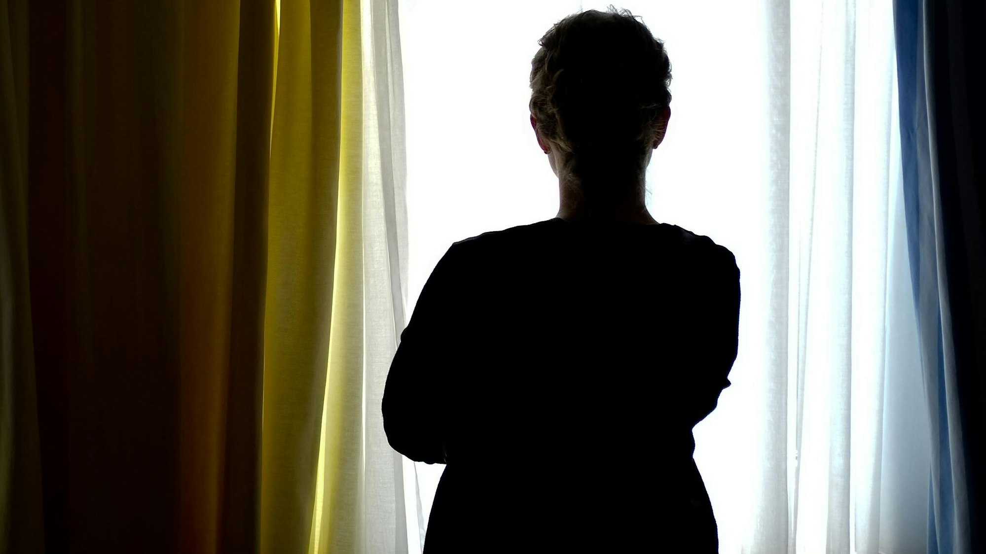 Eine junge Frau steht in einem Zimmer eines Frauenhauses.