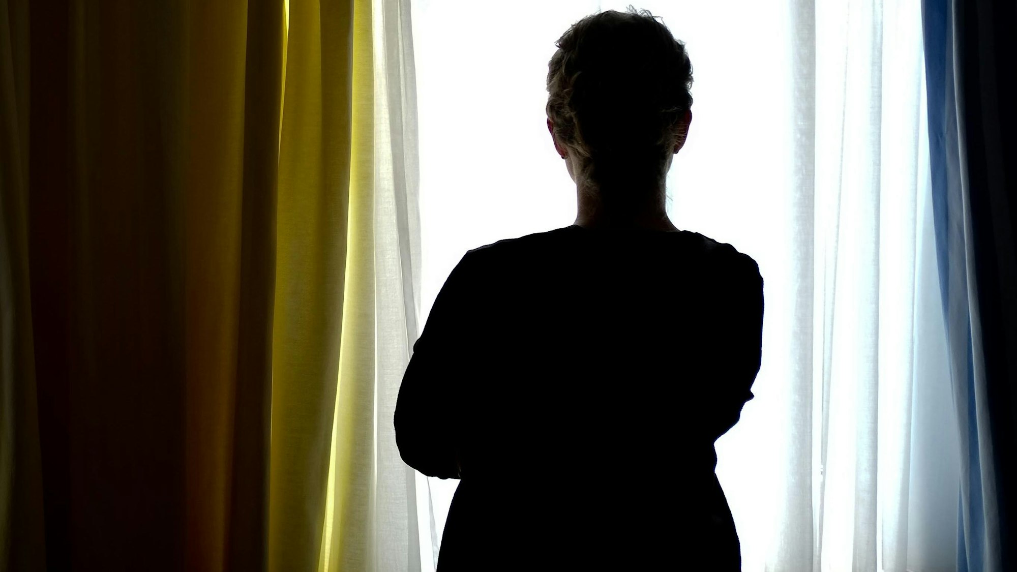 Eine junge Frau steht in einem Zimmer eines Frauenhauses.