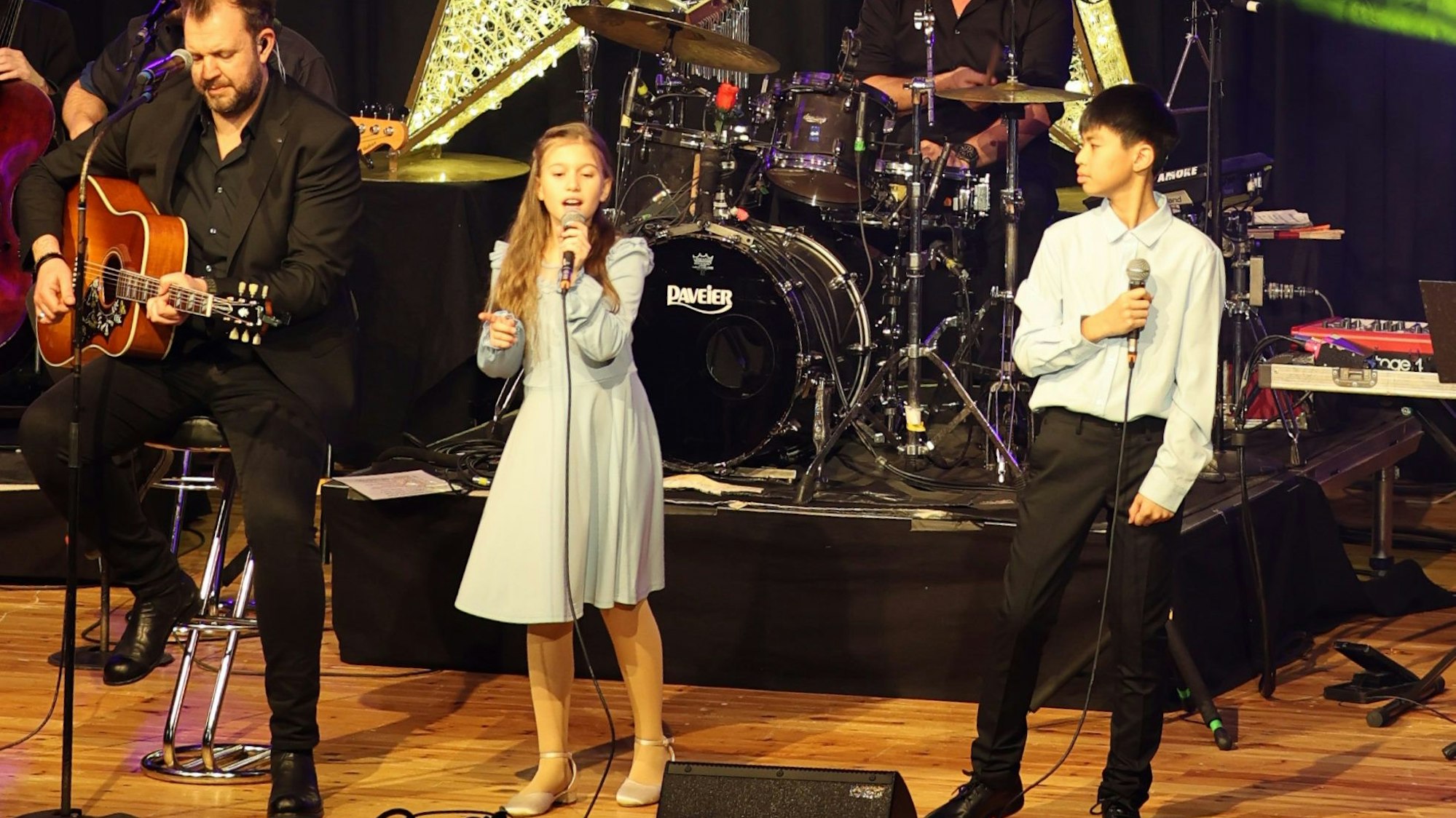 Das Bild zeigt die Kinder neben Sänger und Gitarrist Sven Welter.