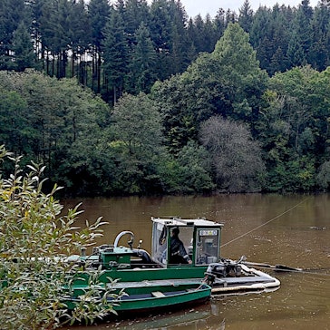 Ein Schwimmbagger ist im Vorstau des Kronenburger Sees im Einsatz. Er entfernt die Sedimente