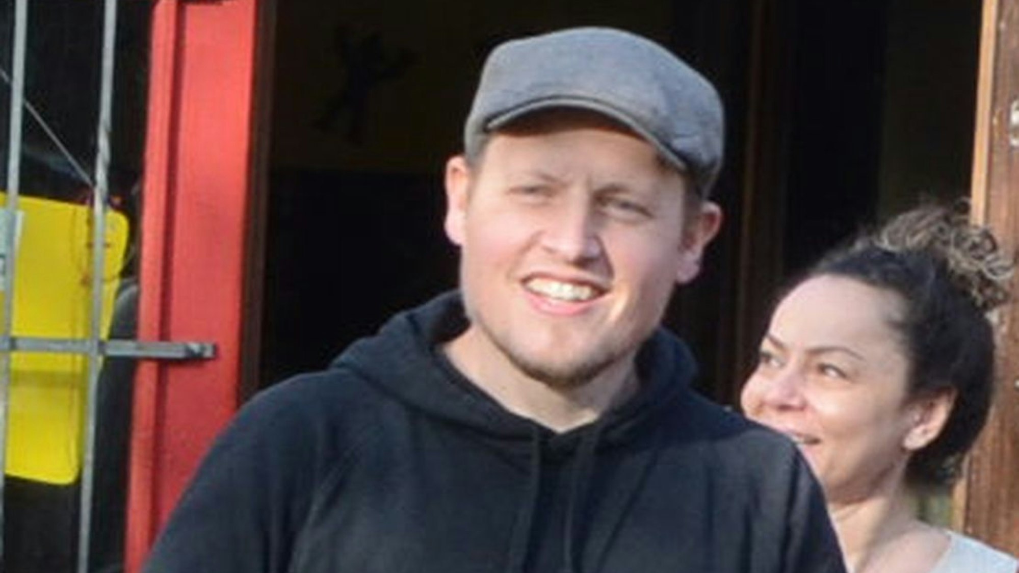 Ein Mann mit einer Schiebermütze trägt eine Umzugskiste.