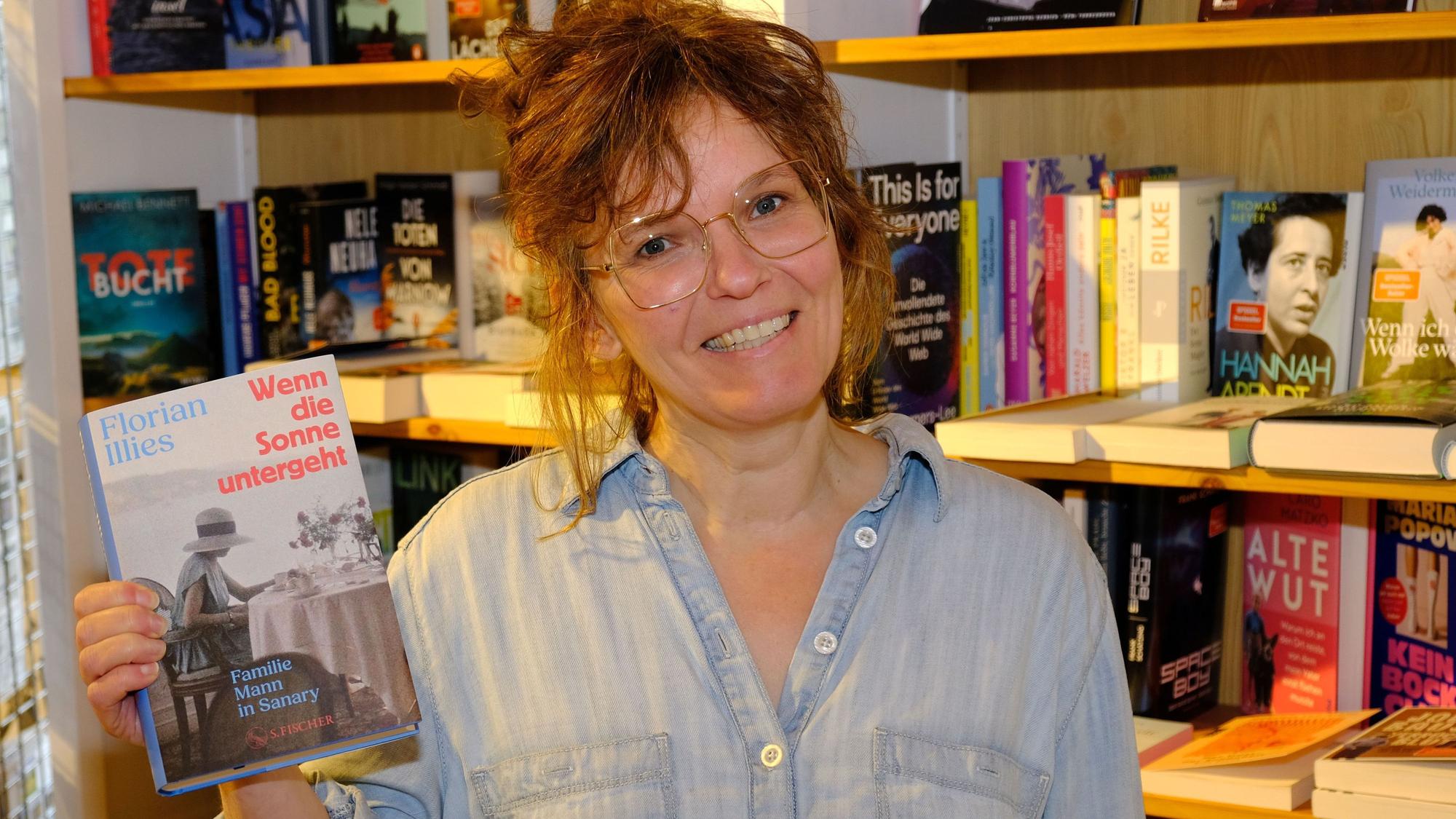 Das Bild zeigt Rosa Wirtz, die ein Buch in der rechten Hand hält.