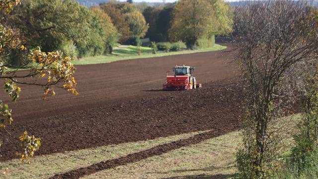 Zu sehen ist ein Traktor auf einem Feld.