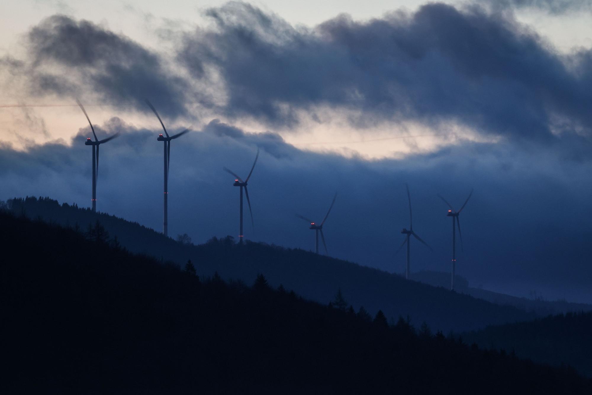 Windräder drehen sich auf einem Berg vor bewölktem Himmel. Foto: Christoph Reichwein/dpa +++ dpa-Bildfunk +++