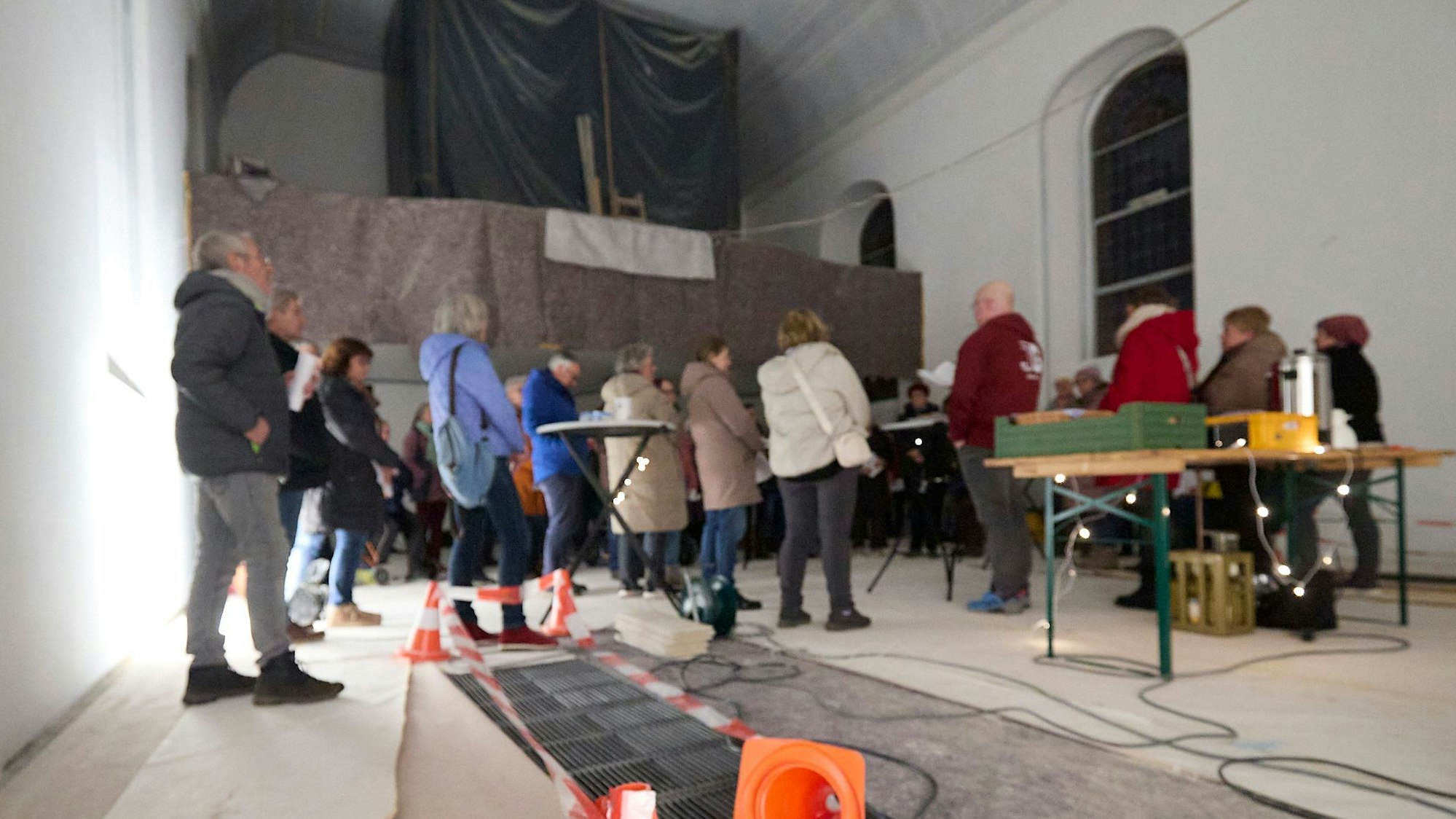 Menschen stehen in der Kirche und singen. Im Hintergrund ist die eingehauste Orgel zu sehen.