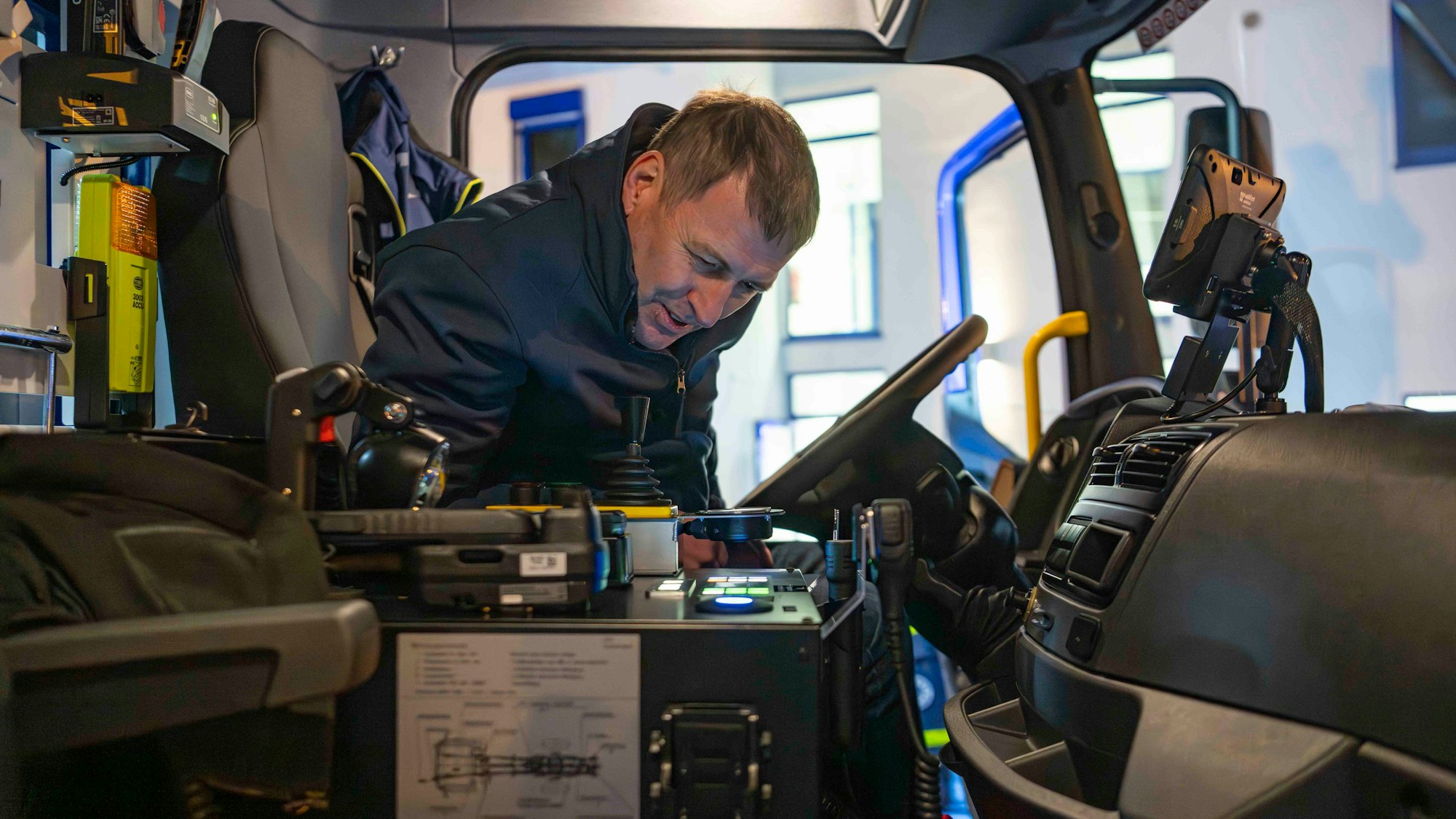 Zugführer Burkhart Aehlich sitzt auf dem Fahrersitz und sieht sich das neue Fahrzeug an.