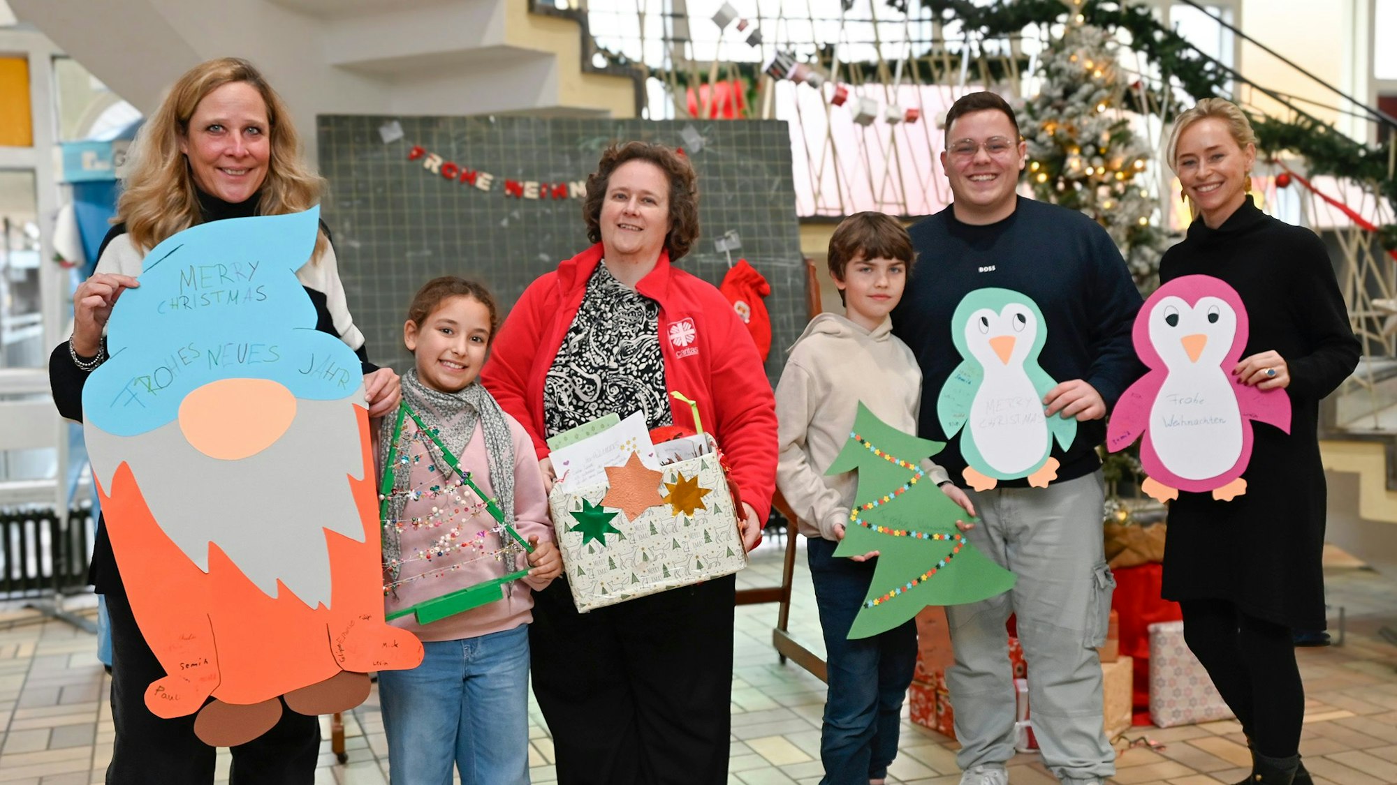 Das Foto zeigt die Beteiligten mit einigen gebastelten Weihnachtsgrüßen bei der Übergabe.