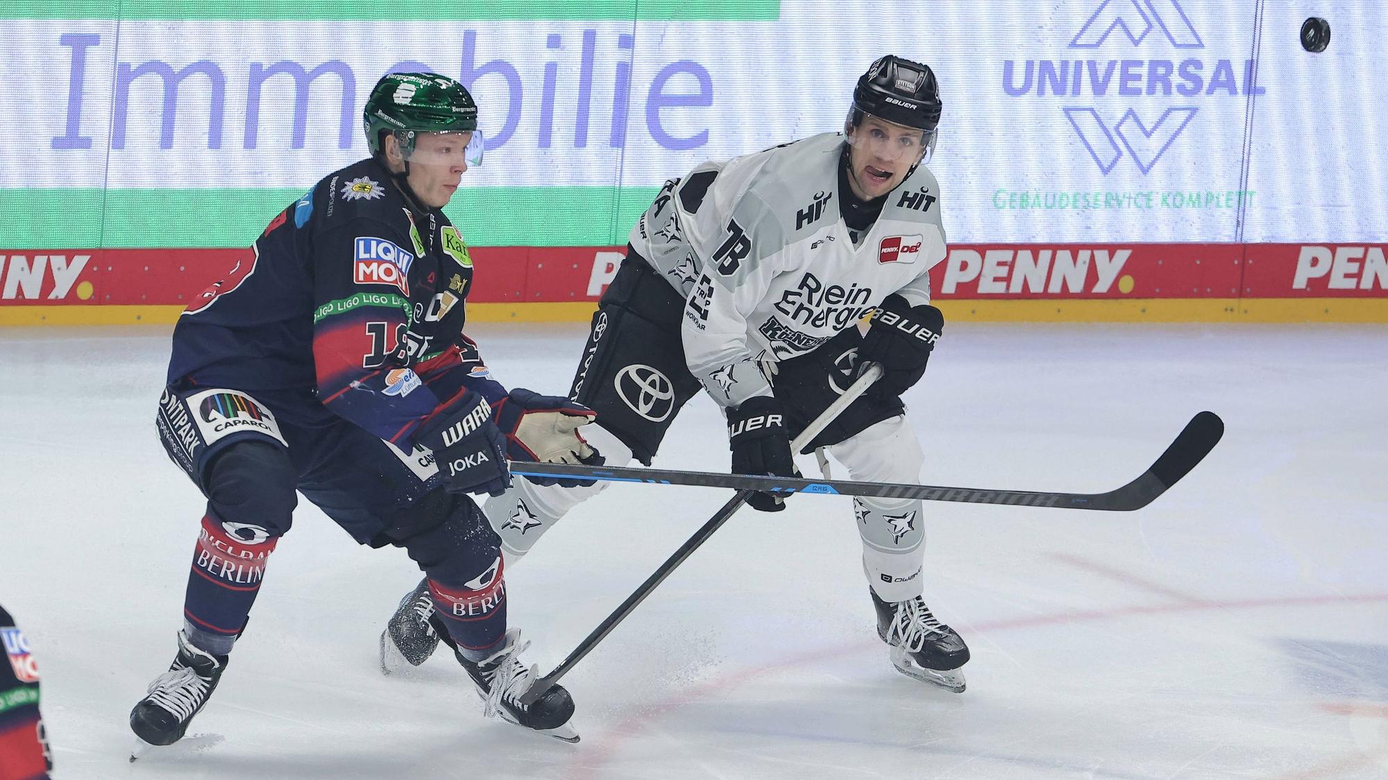 Berlins Kapitän Jonas Müller (l.) und Haie-Stürmer Dominik Bokk im Zweikampf.