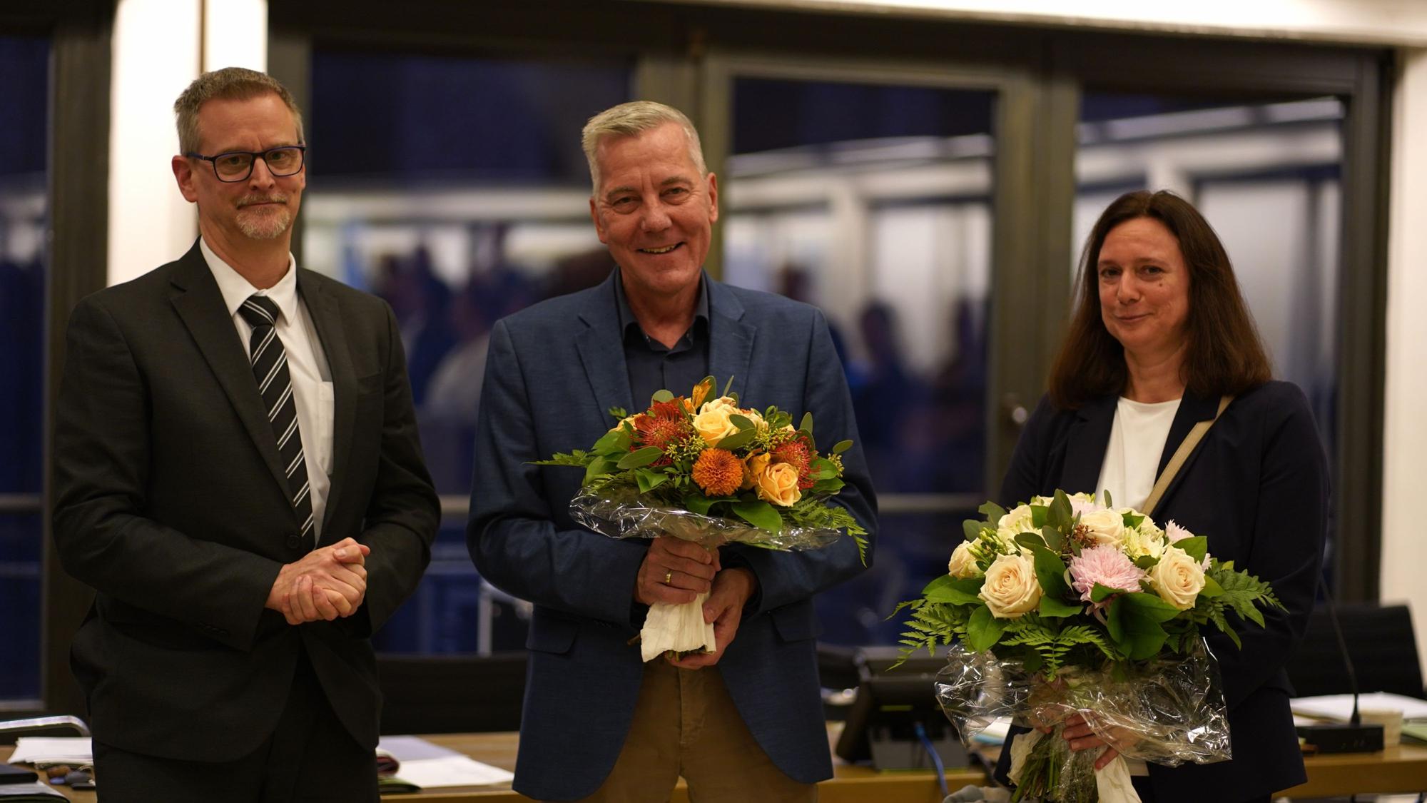 Das Foto zeigt zwei Männer und eine Frau.