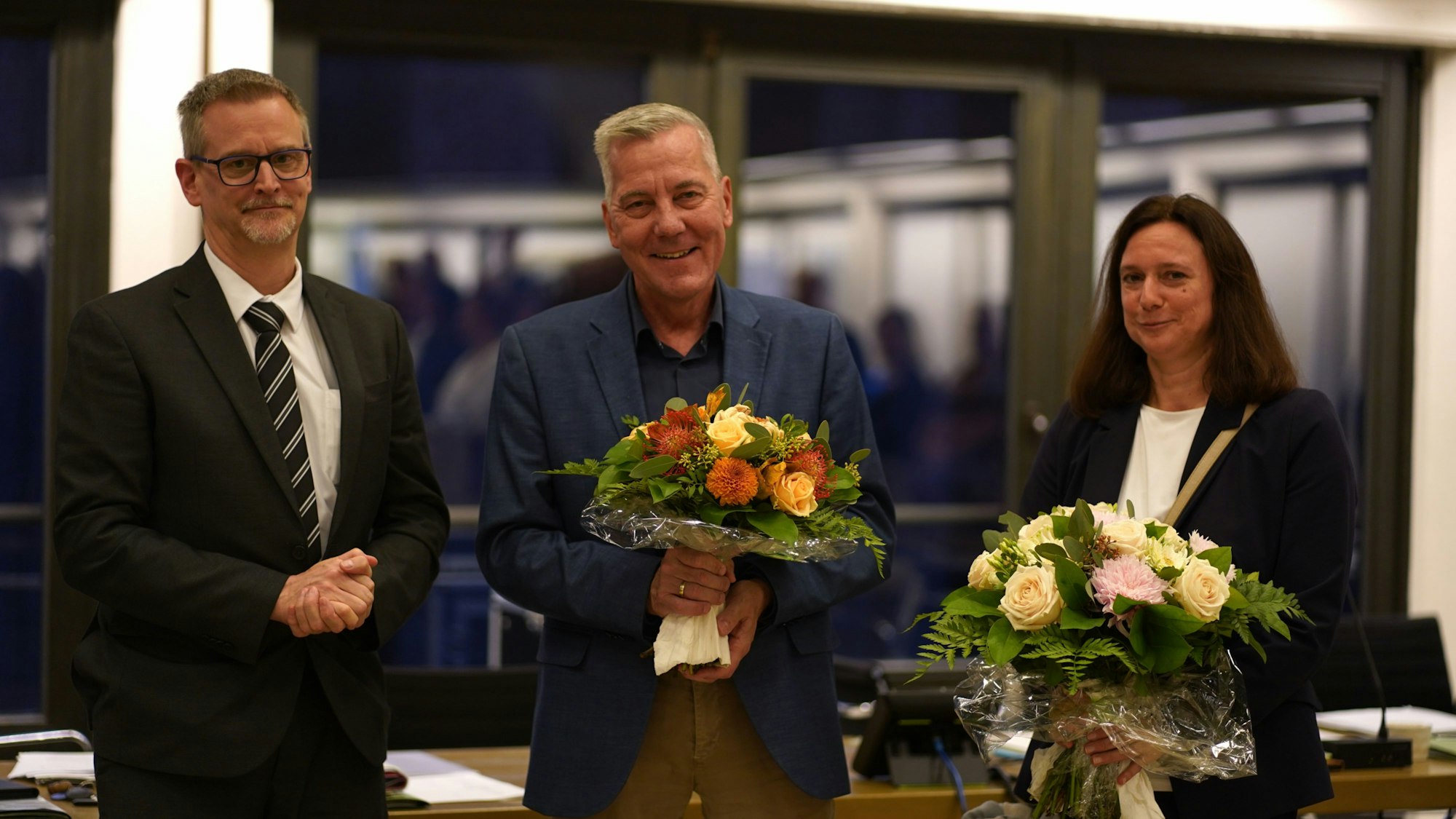 Das Foto zeigt zwei Männer und eine Frau.