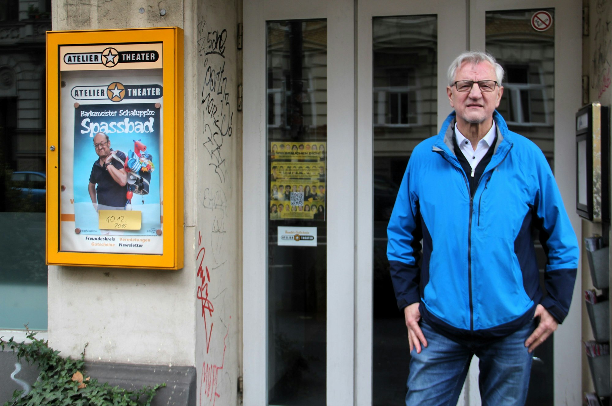 Ein Mann im blauen Anorak steht vor dem Eingang des Atelier-Theaters.
