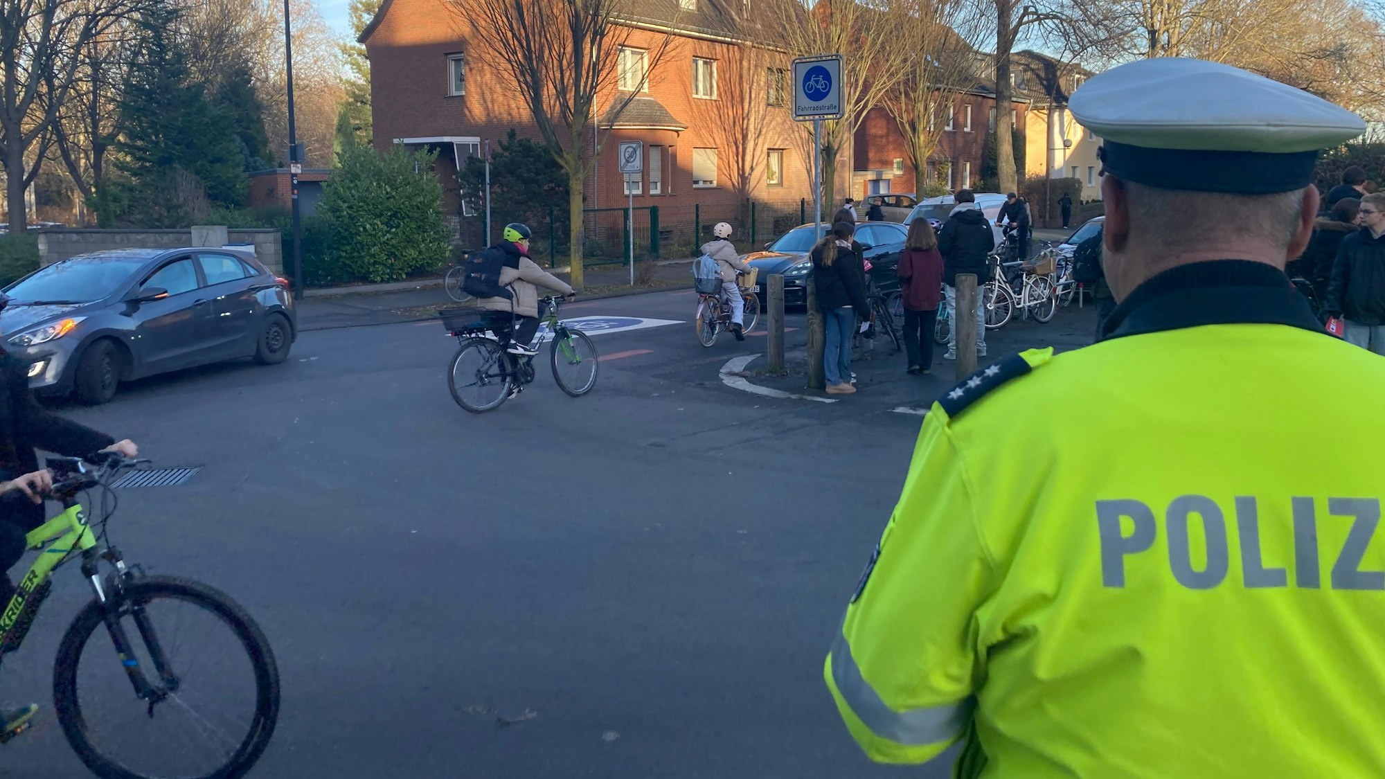 Das Foto zeigt einen Polizisten, Radfahrer und Schüler an der Bonnstraße.