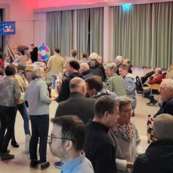 Blick in einen Saal, in dem sich Menschen unterhalten
