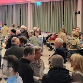 Blick in einen Saal, in dem sich Menschen unterhalten