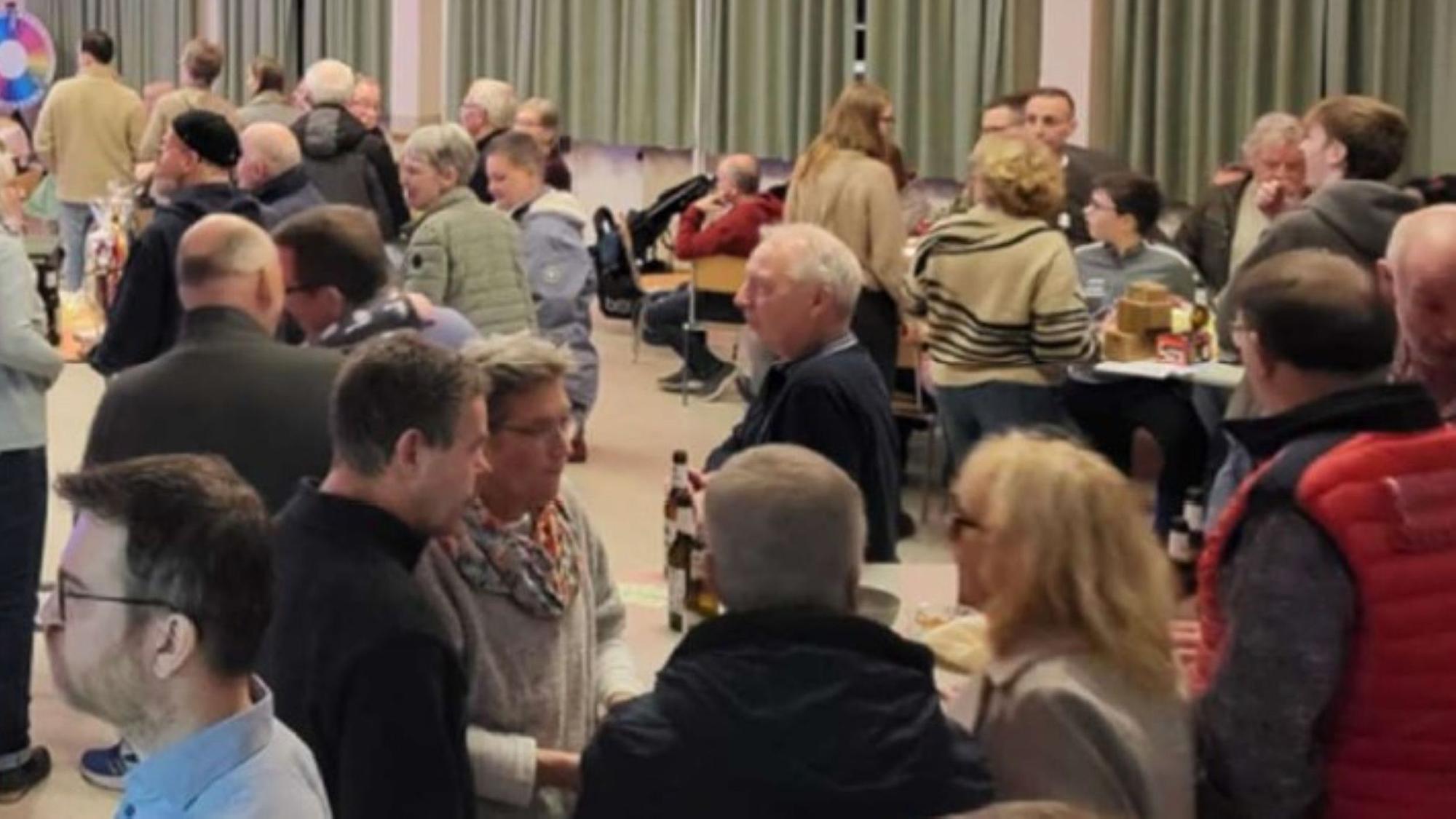 Blick in einen Saal, in dem sich Menschen unterhalten