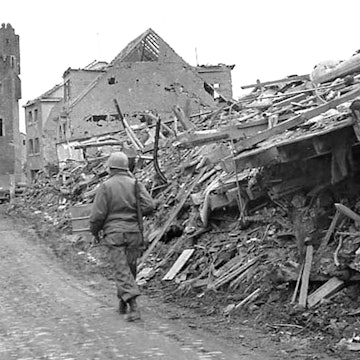 Ein Soldat geht zwischen Trümmerbergen auf das Stadttor zu.