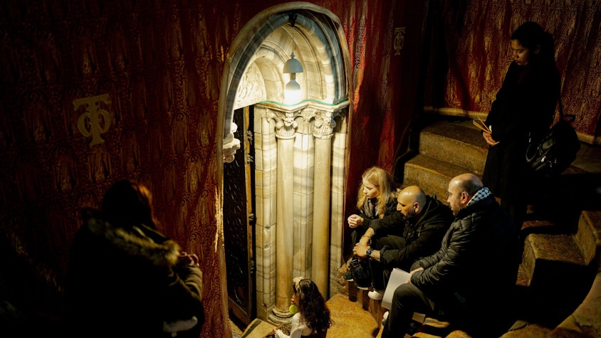 dpatopbilder - 21.12.2025, Palästinensische Gebiete, Bethlehem: Christen sitzen auf den Stufen der Grotte unter der Basilika, dem angeblichen Geburtsort Jesu Christi, in der Geburtskirche in der Stadt Bethlehem im Westjordanland, wenige Tage vor den Weihnachtsfeierlichkeiten. Foto: Erik Marmor/dpa +++ dpa-Bildfunk +++