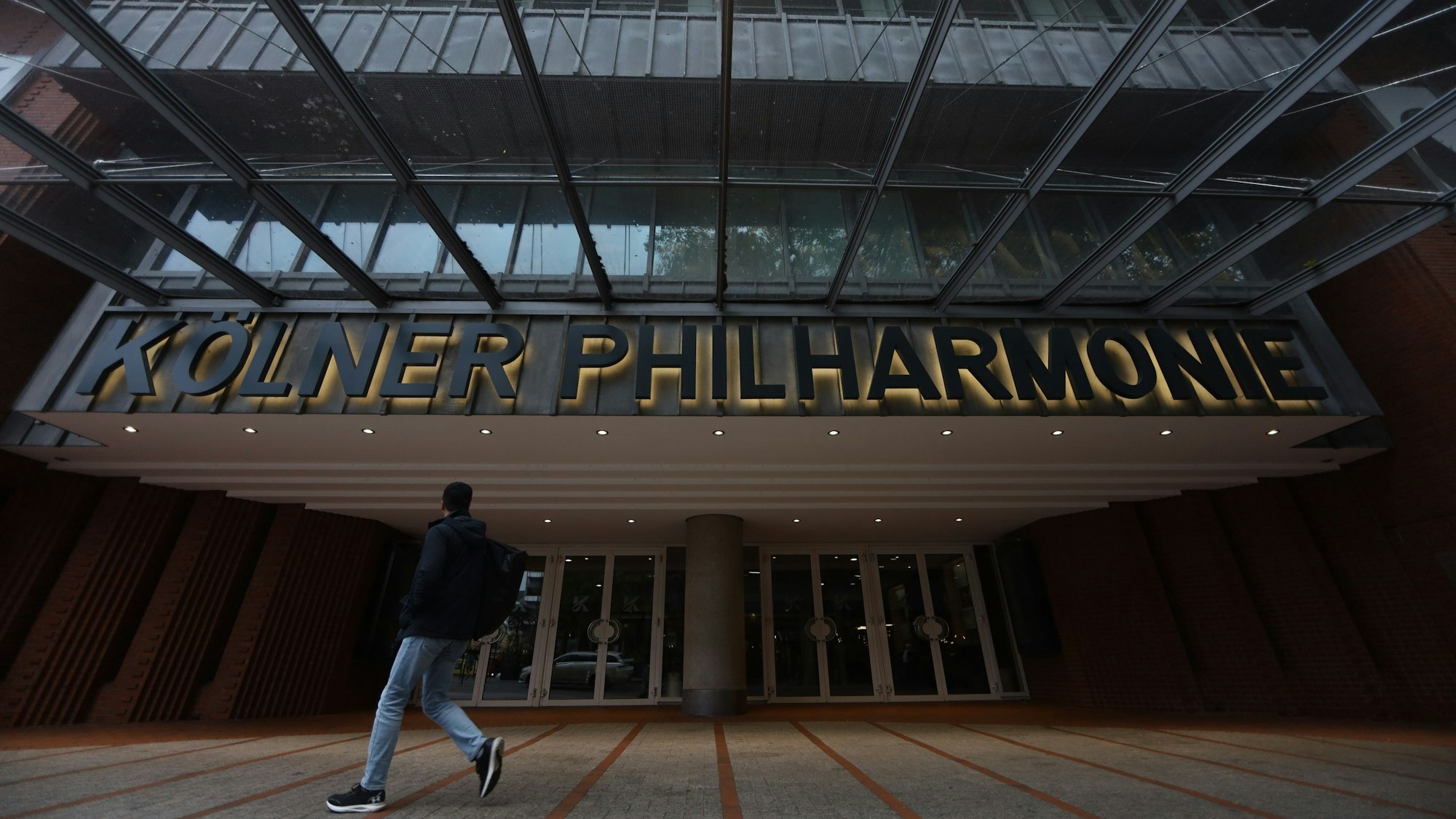Ein Mann geht an der Philharmonie vorbei.