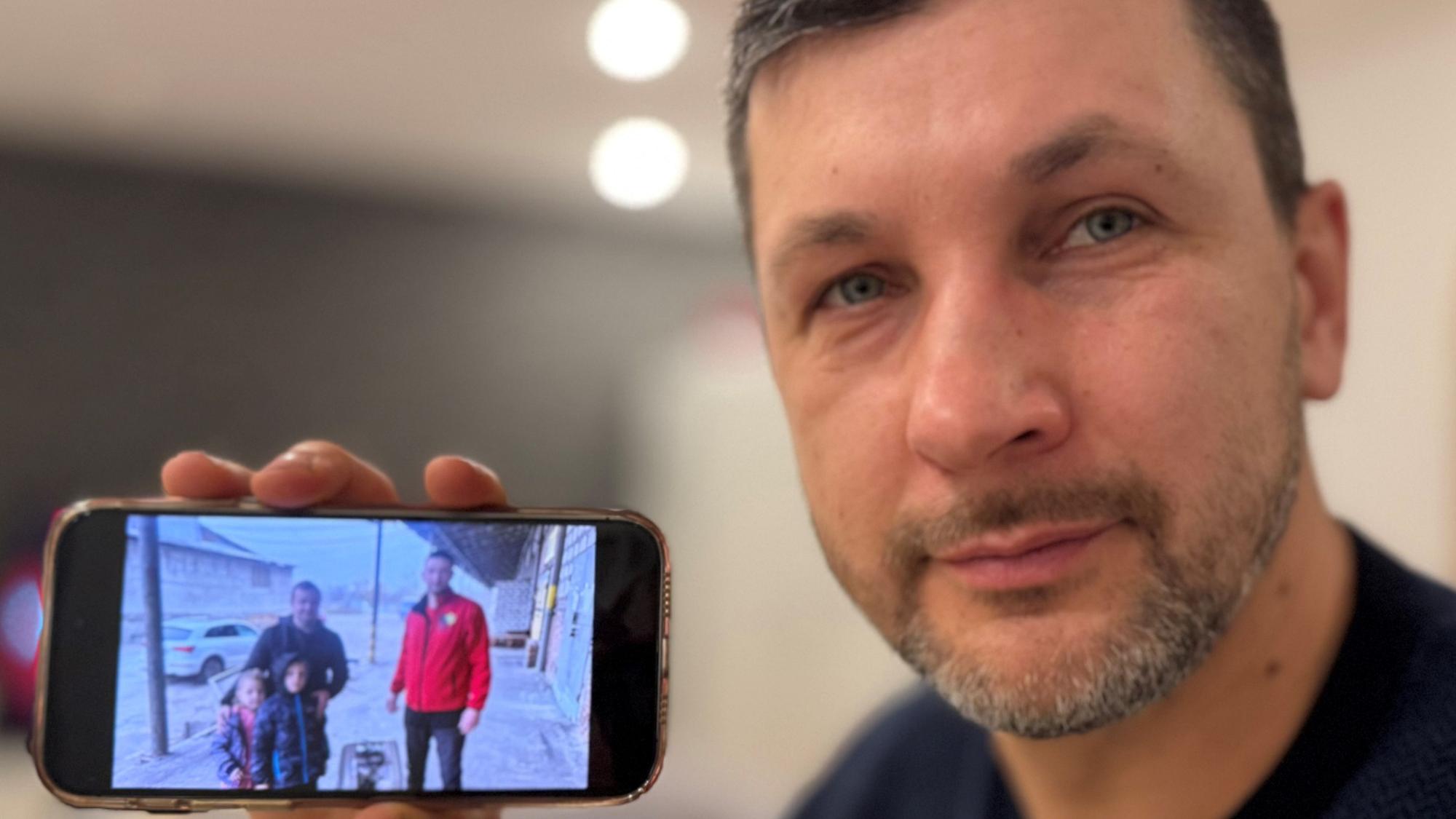 Jakiv Syromiatnykov zeigt ein Foto von seinem Bruder in Charkiw.
