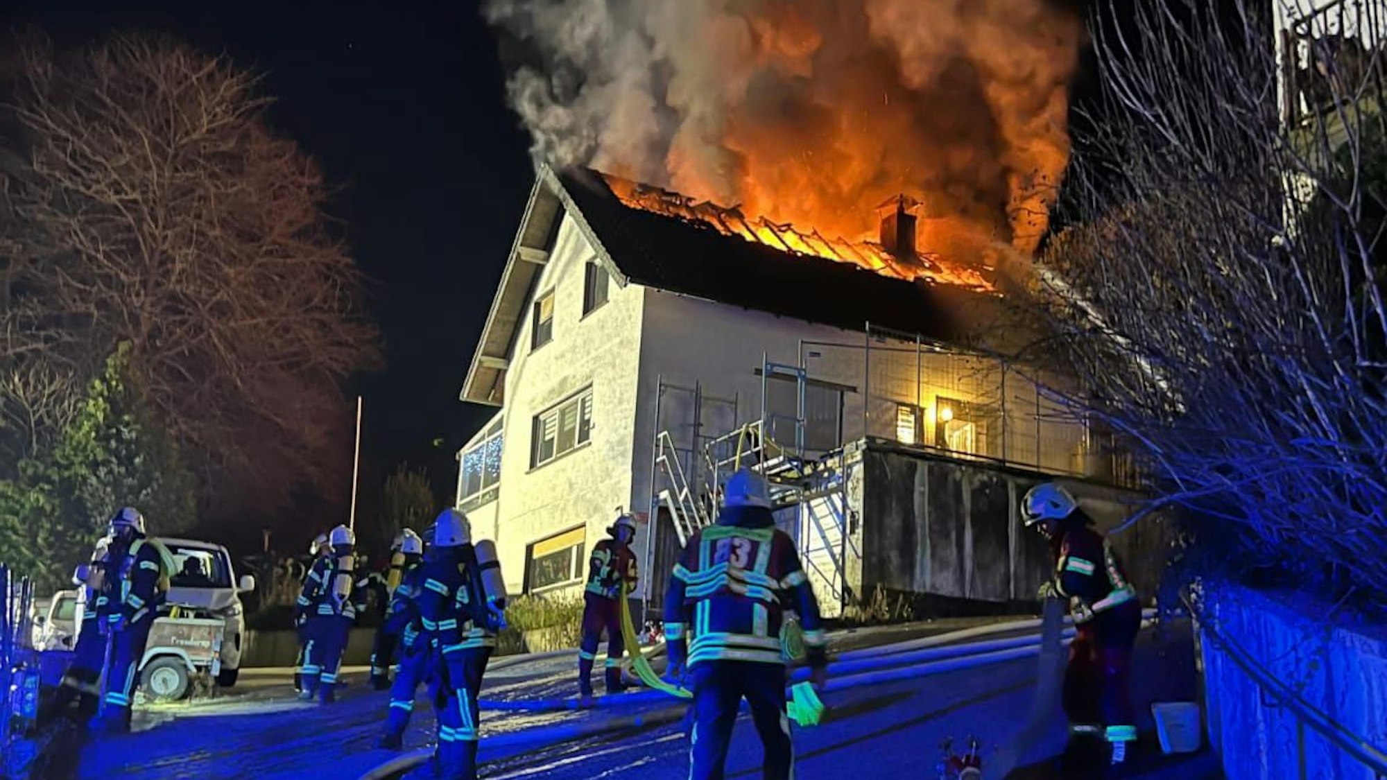 Flammen schlagen aus einem brennenden Zwei-Parteien-Hauses an der Nallinger Straße in Overath-Steinenbrück brennt am Freitagabend (26.12.).