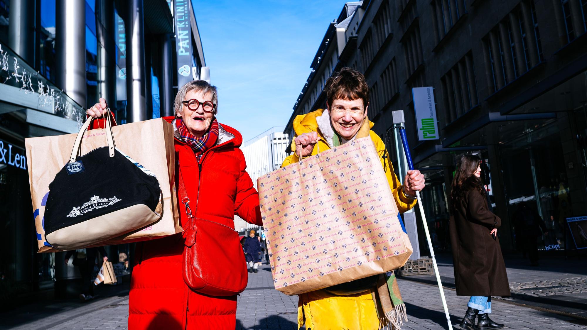 Astrid Henschke (l.) und Renate Heim kommen mit vollen Taschen vom Einkaufsbummel zurück.