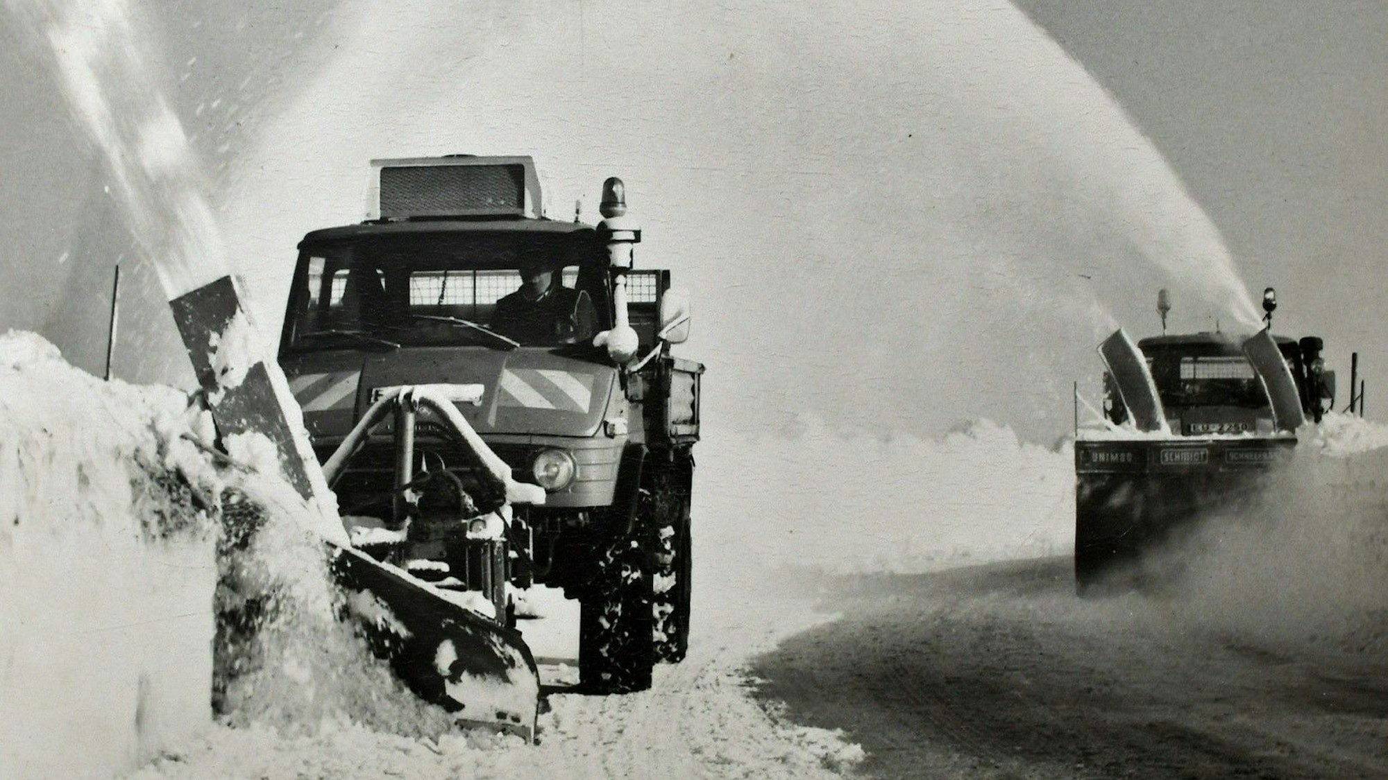 Das Archivfoto zeigt zwei Räumfahrzeuge, die seitlich versetzt im Winter 1978 eine Straße freiräumen.