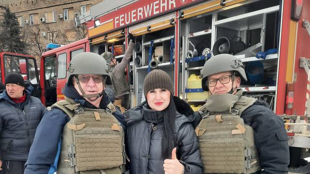 Alfred Eich, Olga uund Andreas Klassen stehen vor dem gespendeten Feuerwehrfahrzeug.