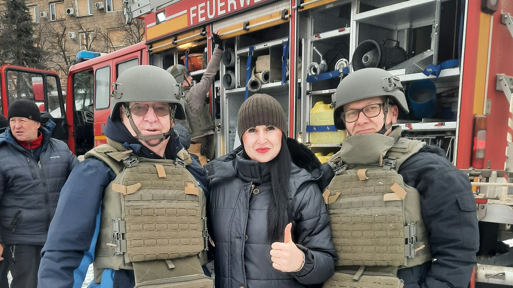 Alfred Eich, Olga uund Andreas Klassen stehen vor dem gespendeten Feuerwehrfahrzeug.