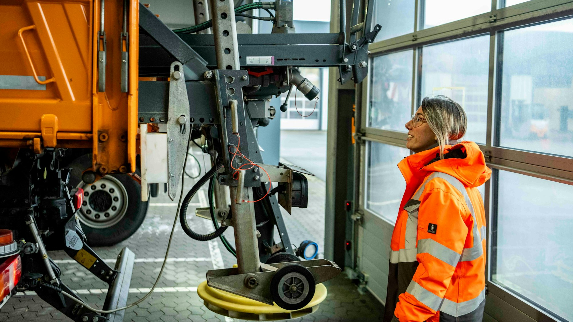 Eva Heinen mustert die Technik des Salzstreuers am Räumfahrzeug.